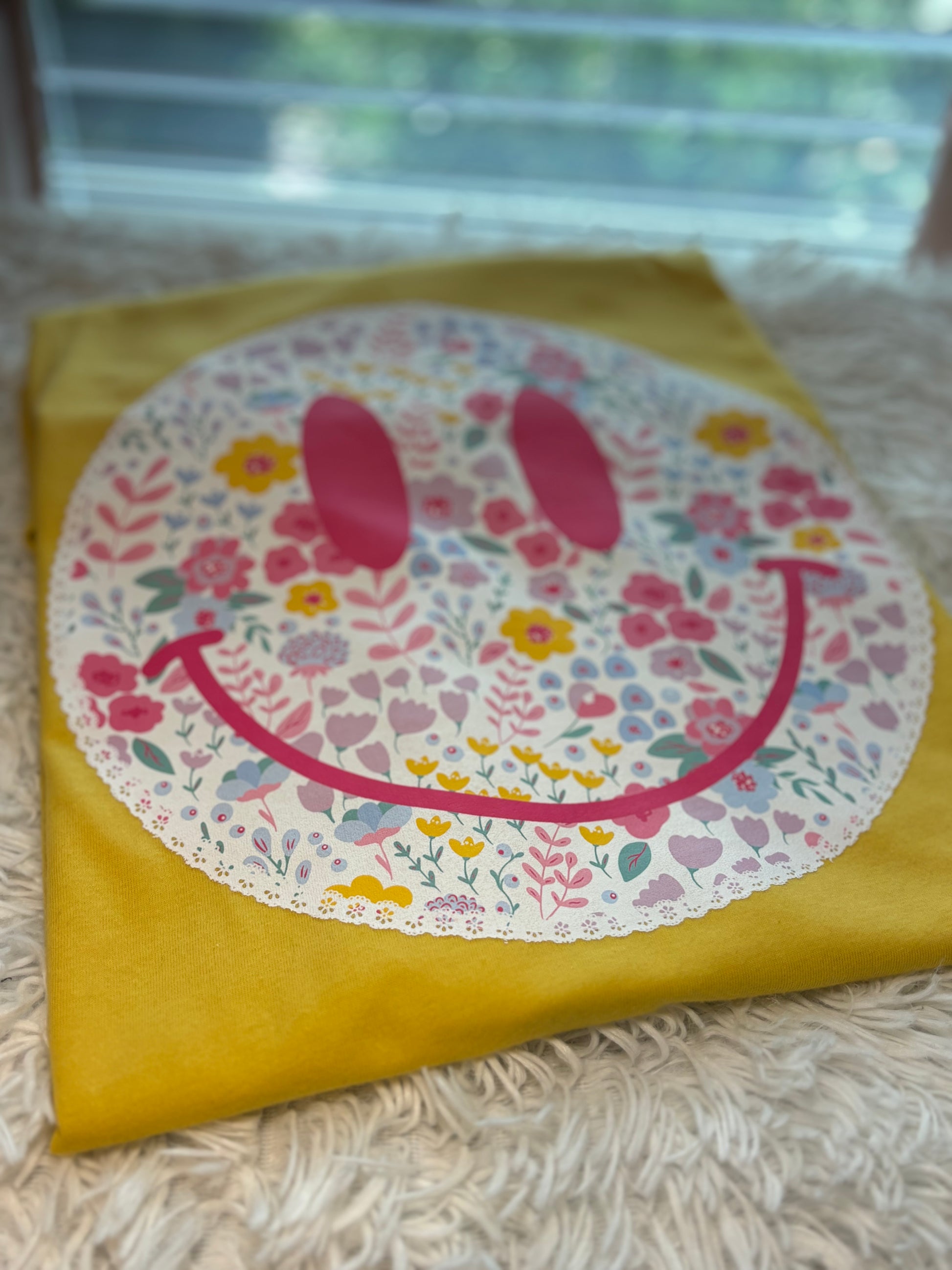 Yellow heat press t-shirt with a floral smiley face design with lace outlining