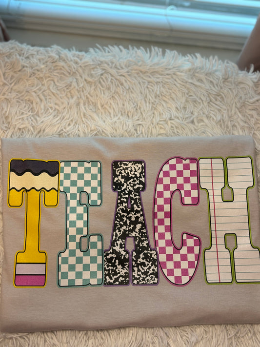Light Grey heat press t-shirt with colorful letters spelling 'TEACH'