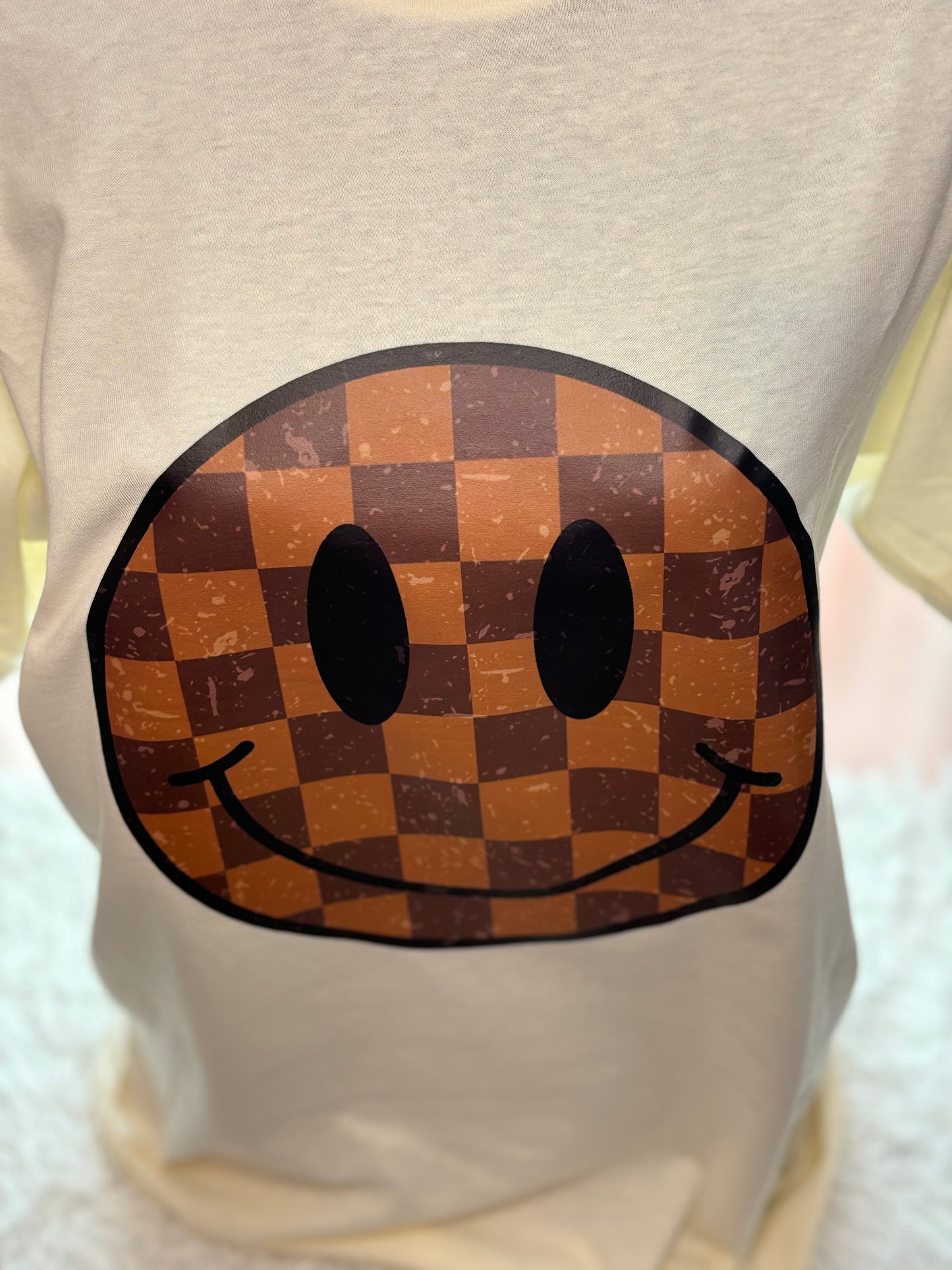 Cream heat press t-shirt with a checkered smiley face design