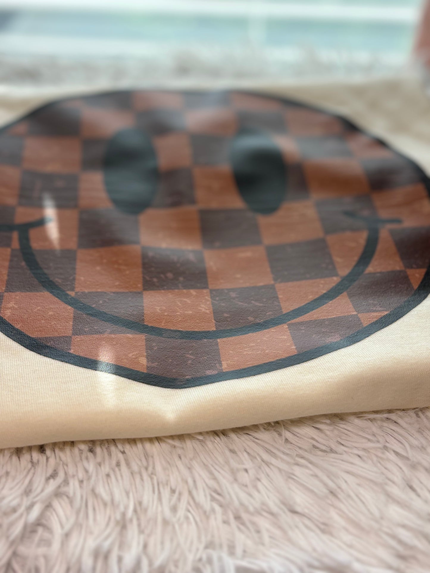 Cream heat press t-shirt with a checkered smiley face design