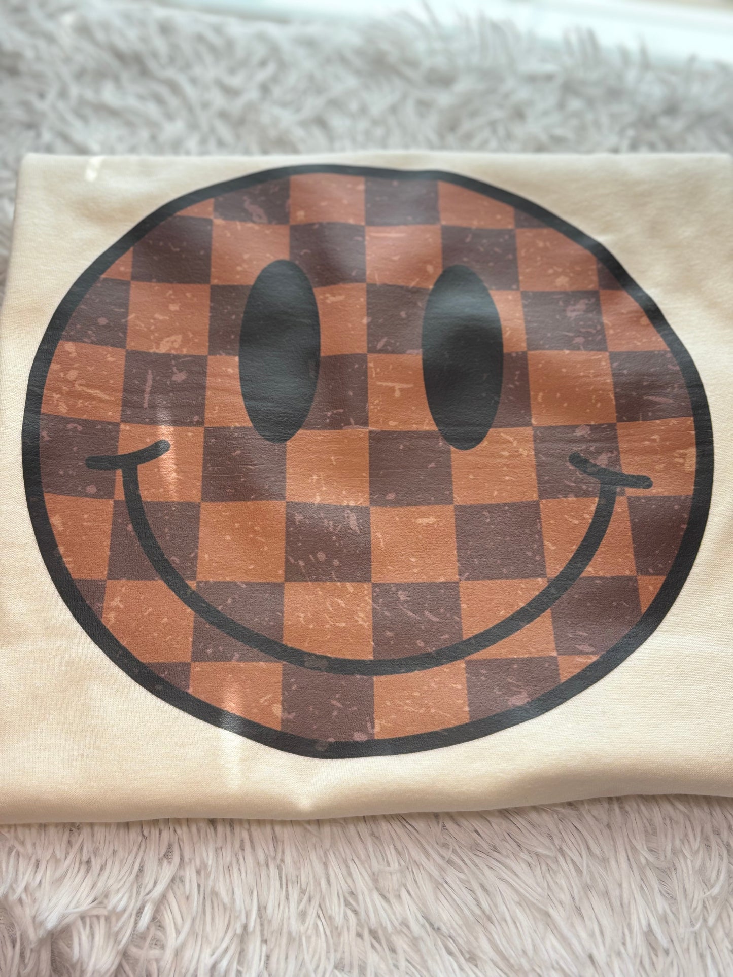Cream heat press t-shirt with a checkered smiley face design