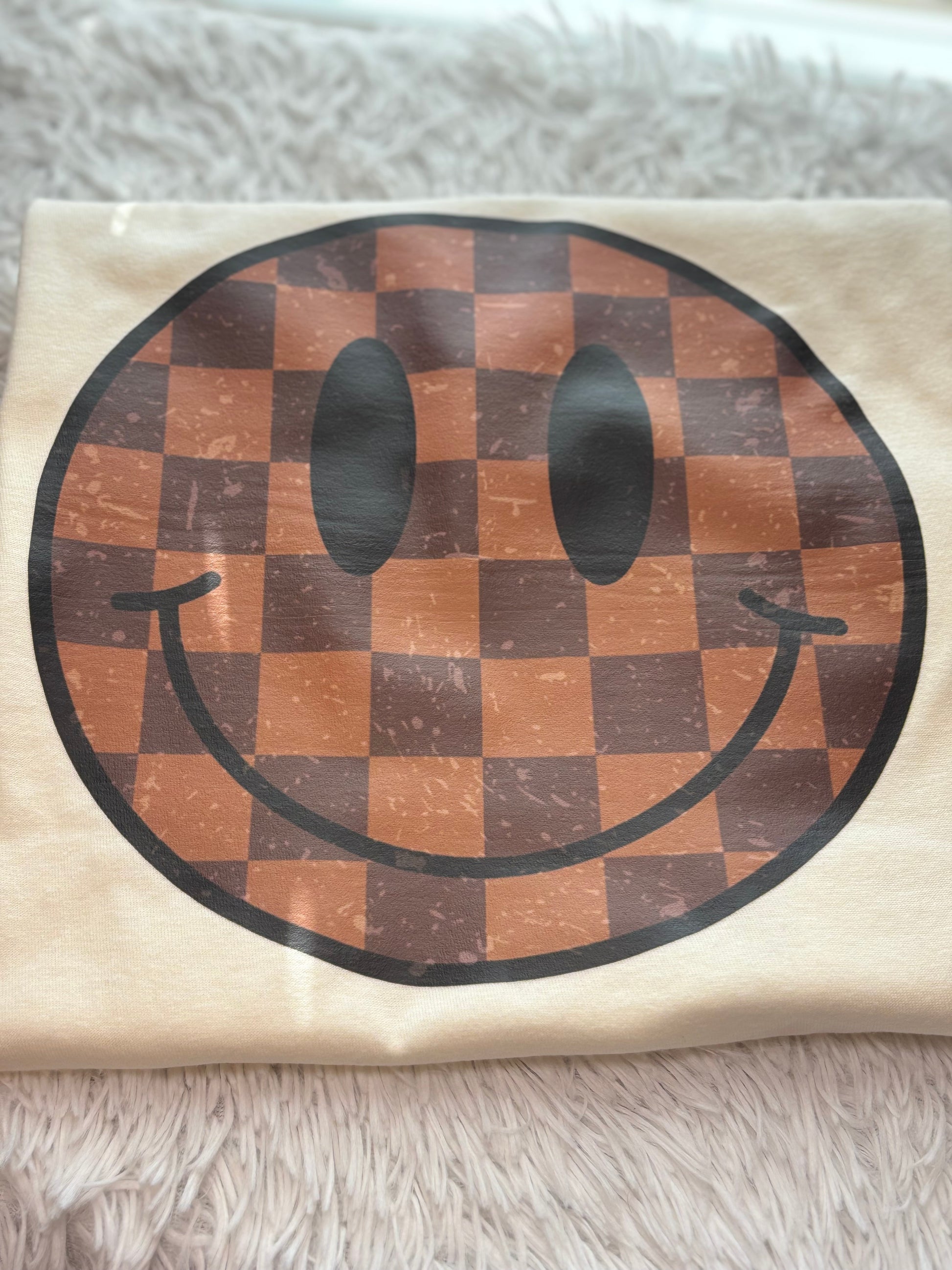 Cream heat press t-shirt with a checkered smiley face design