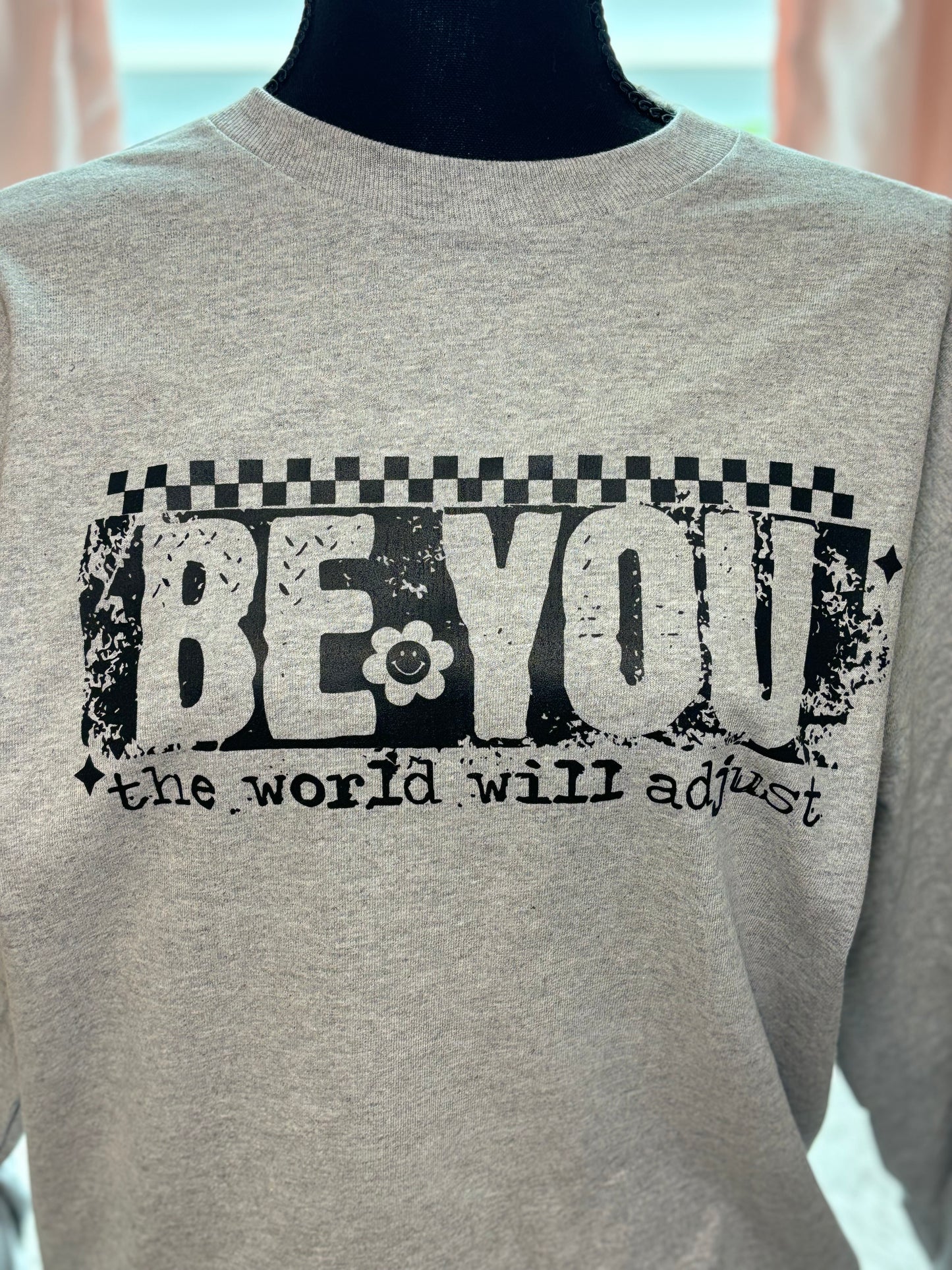 Gray heat press long sleeve t-shirt with 'Be You, the world will adjust' text in black- checker