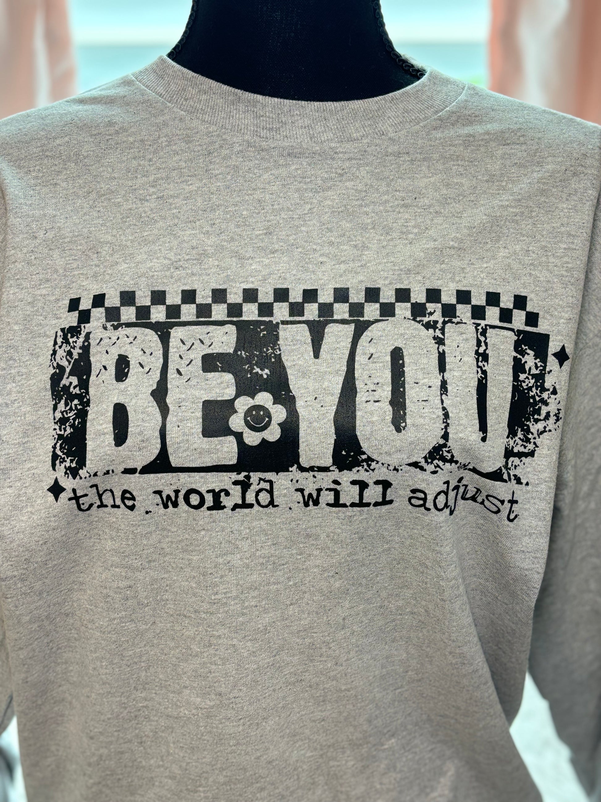 Gray heat press long sleeve t-shirt with 'Be You, the world will adjust' text in black- checker