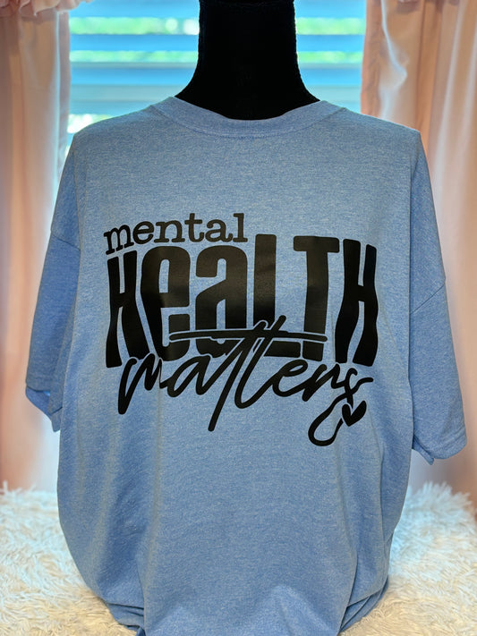 Light blue heat press t-shirt with 'mental health matters' text in black