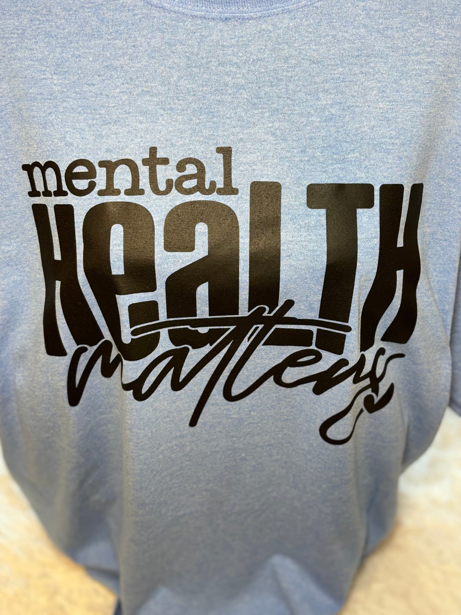 Light blue heat press t-shirt with 'mental health matters' text in black