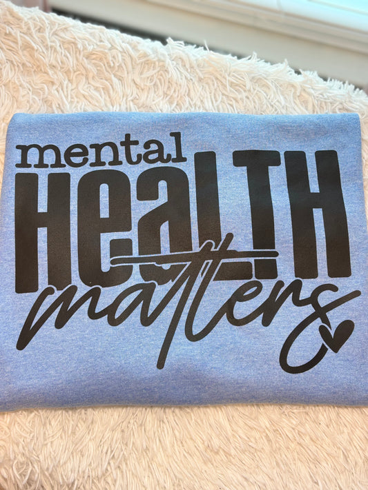 Light blue heat press t-shirt with 'mental health matters' text in black