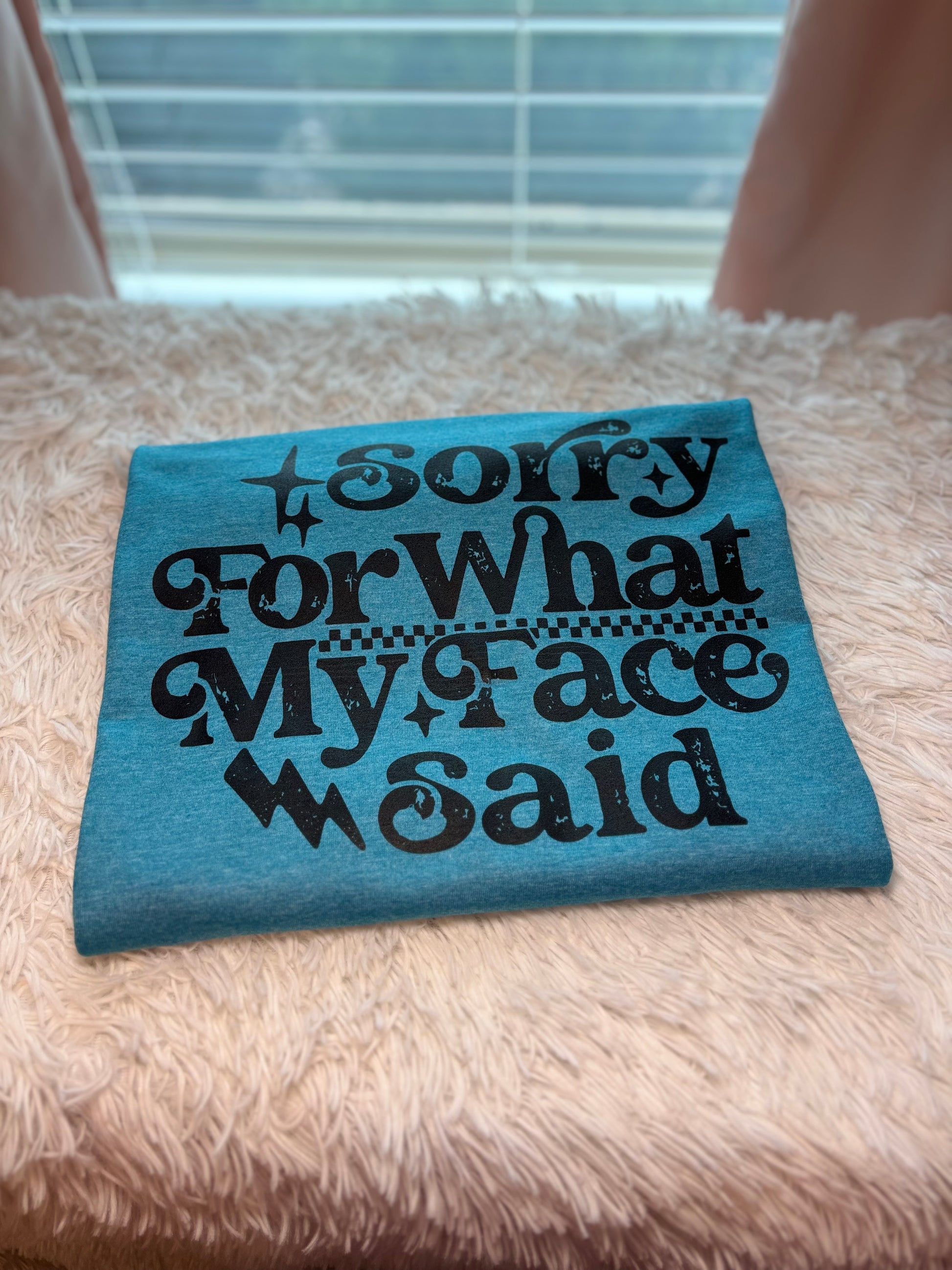 Blue heat press t-shirt with text 'Sorry For What My Face Said' in black