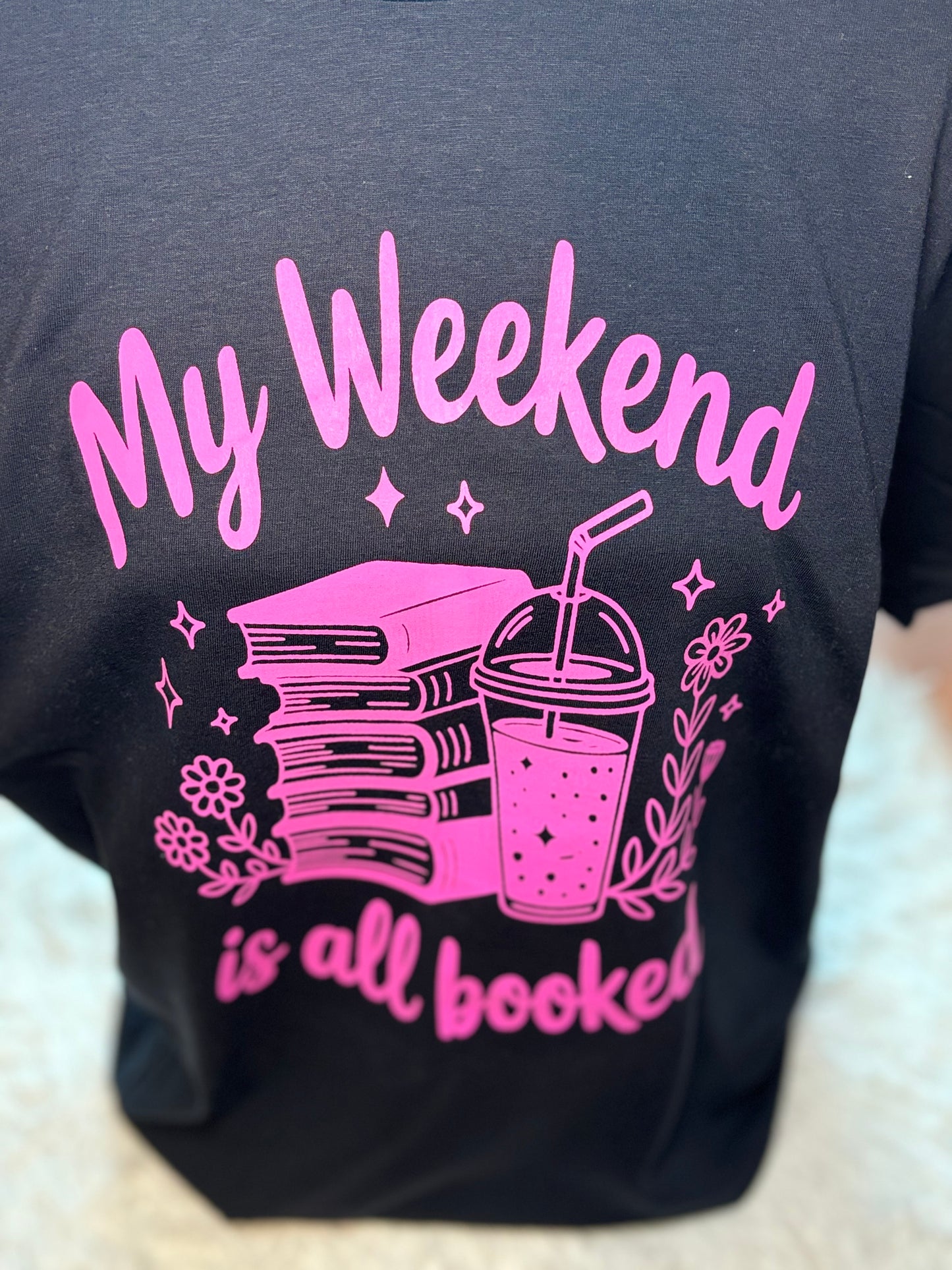 Black heat press t-shirt with neon pink text and graphics - My Weekend is all booked with books. coffee, and flowers