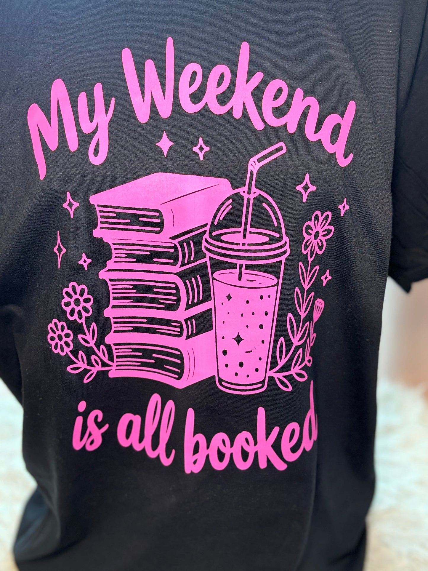 Black heat press t-shirt with neon pink text and graphics - My Weekend is all booked with books. coffee, and flowers