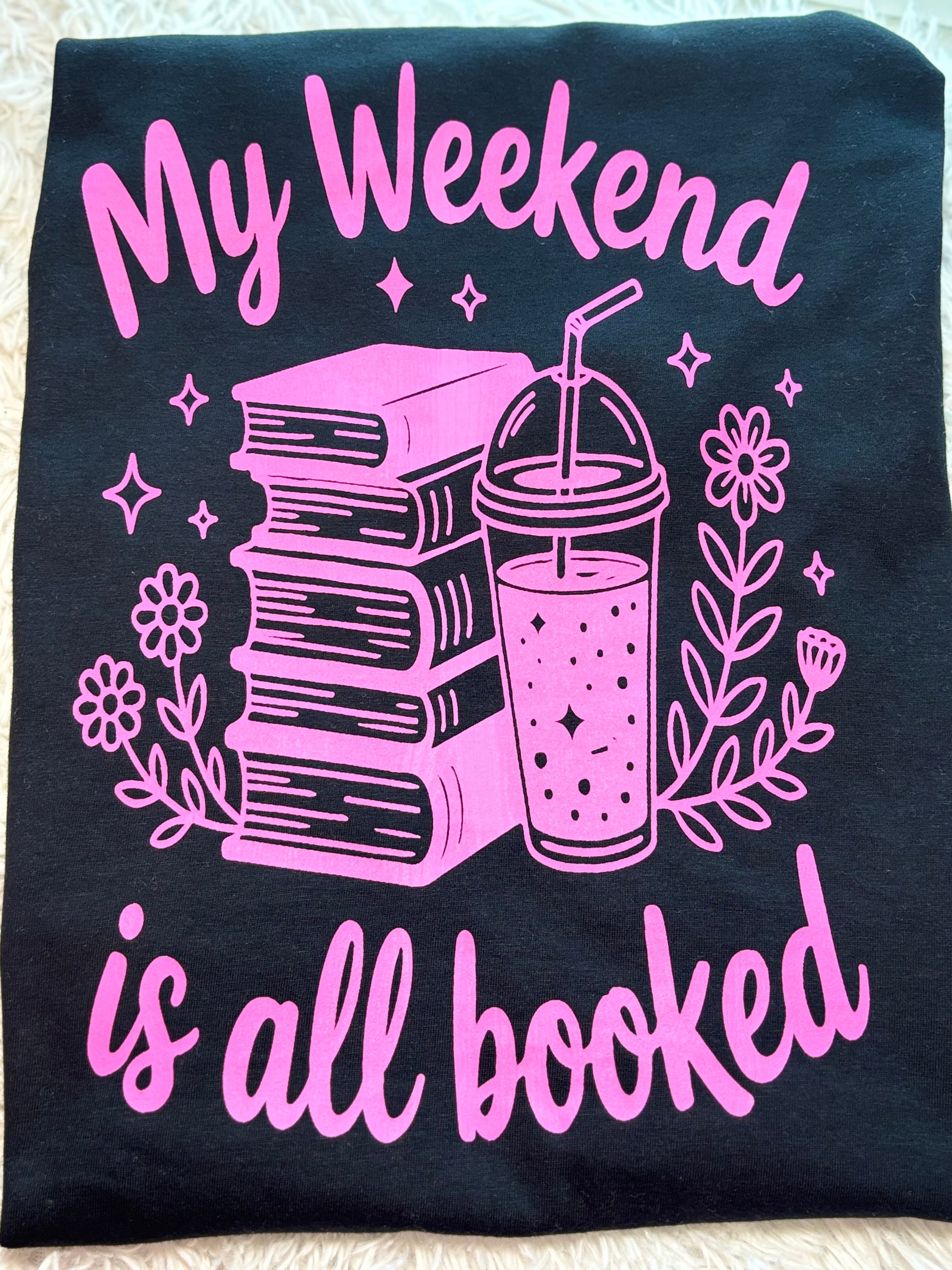Black heat press t-shirt with neon pink text and graphics - My Weekend is all booked with books. coffee, and flowers