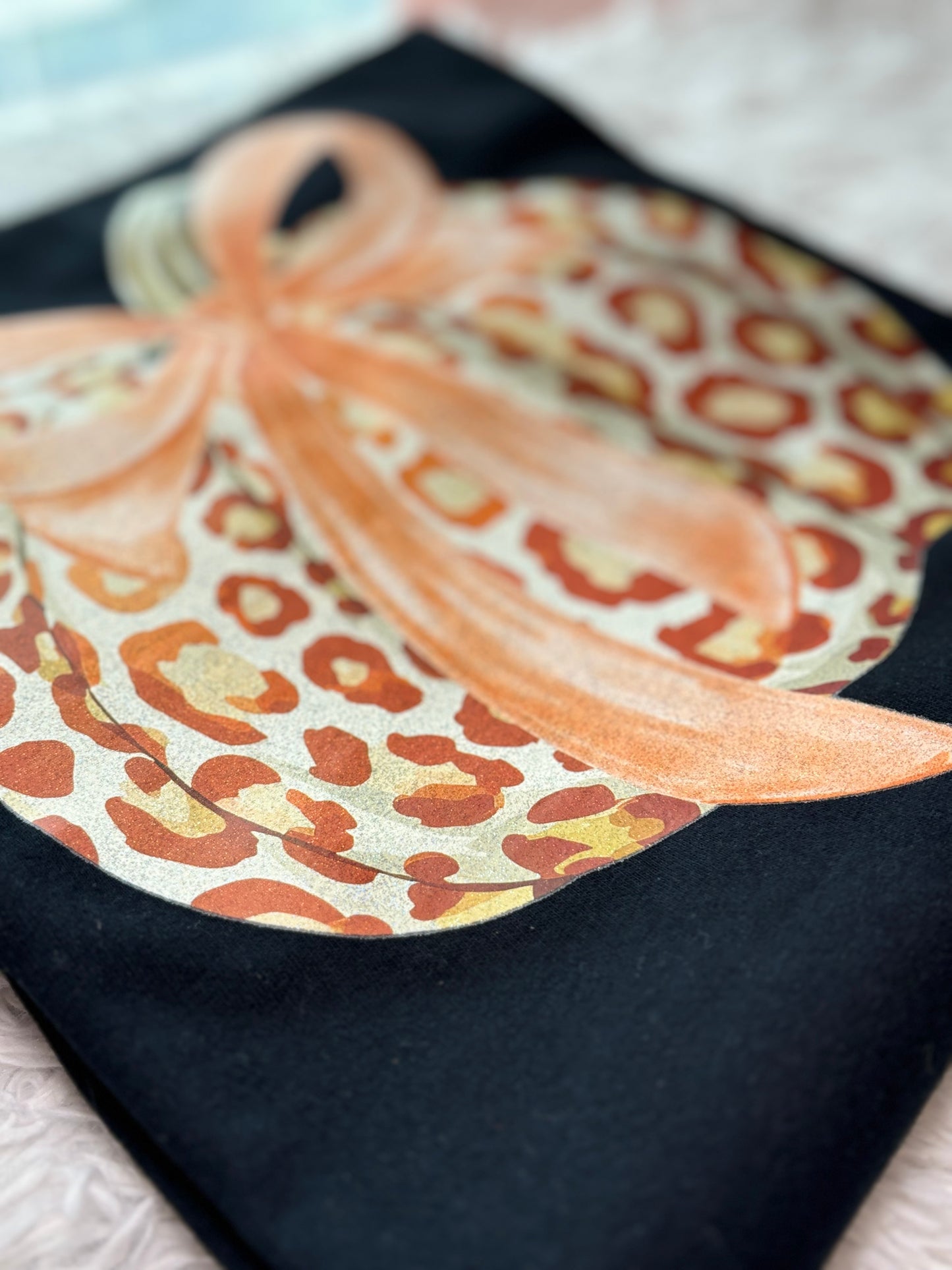 Black t-shirt with a heat press glitter leopard print pumpkin design