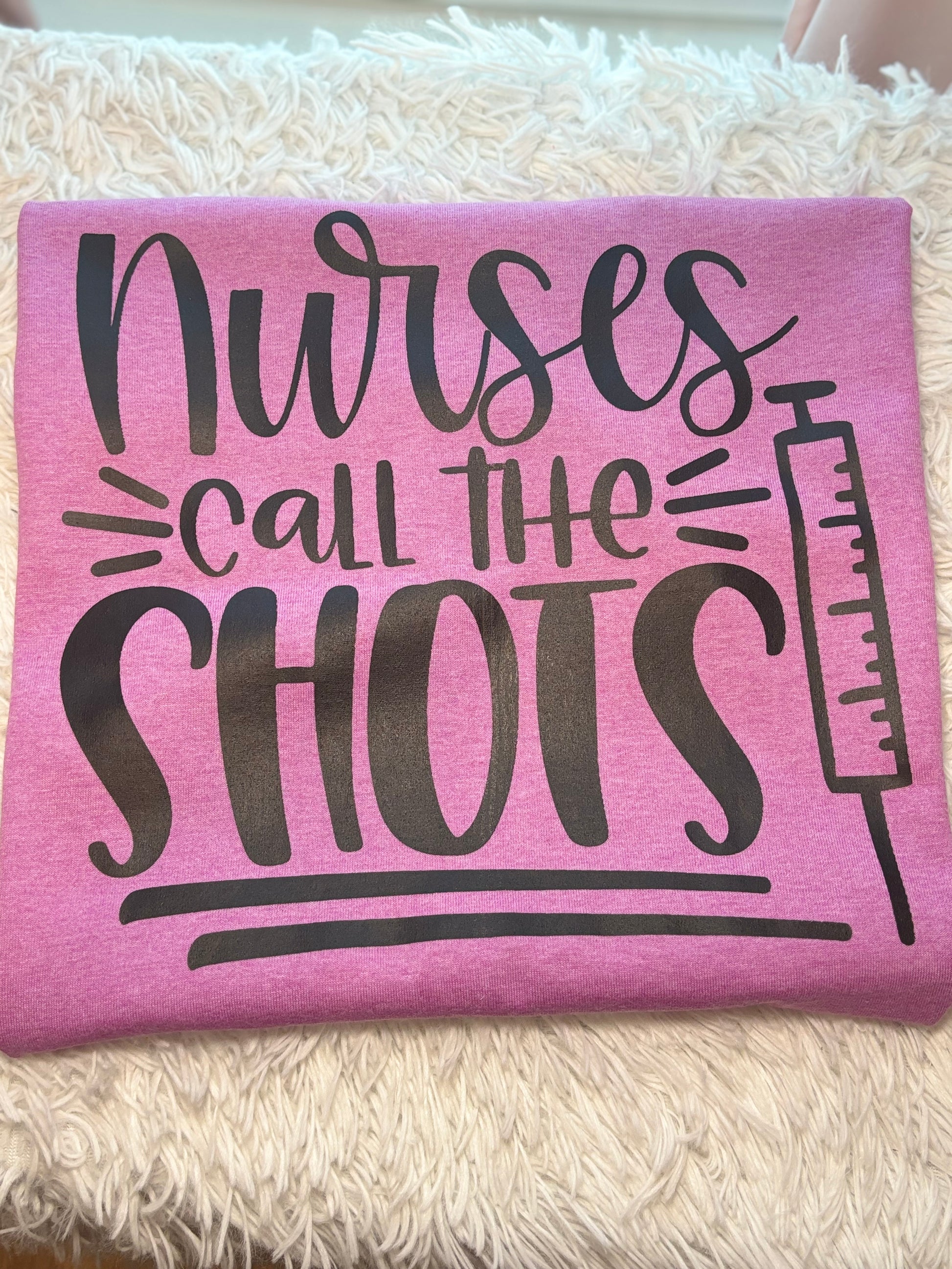Pink heat press t-shirt with 'Nurses call the shots' text and a syringe black graphic