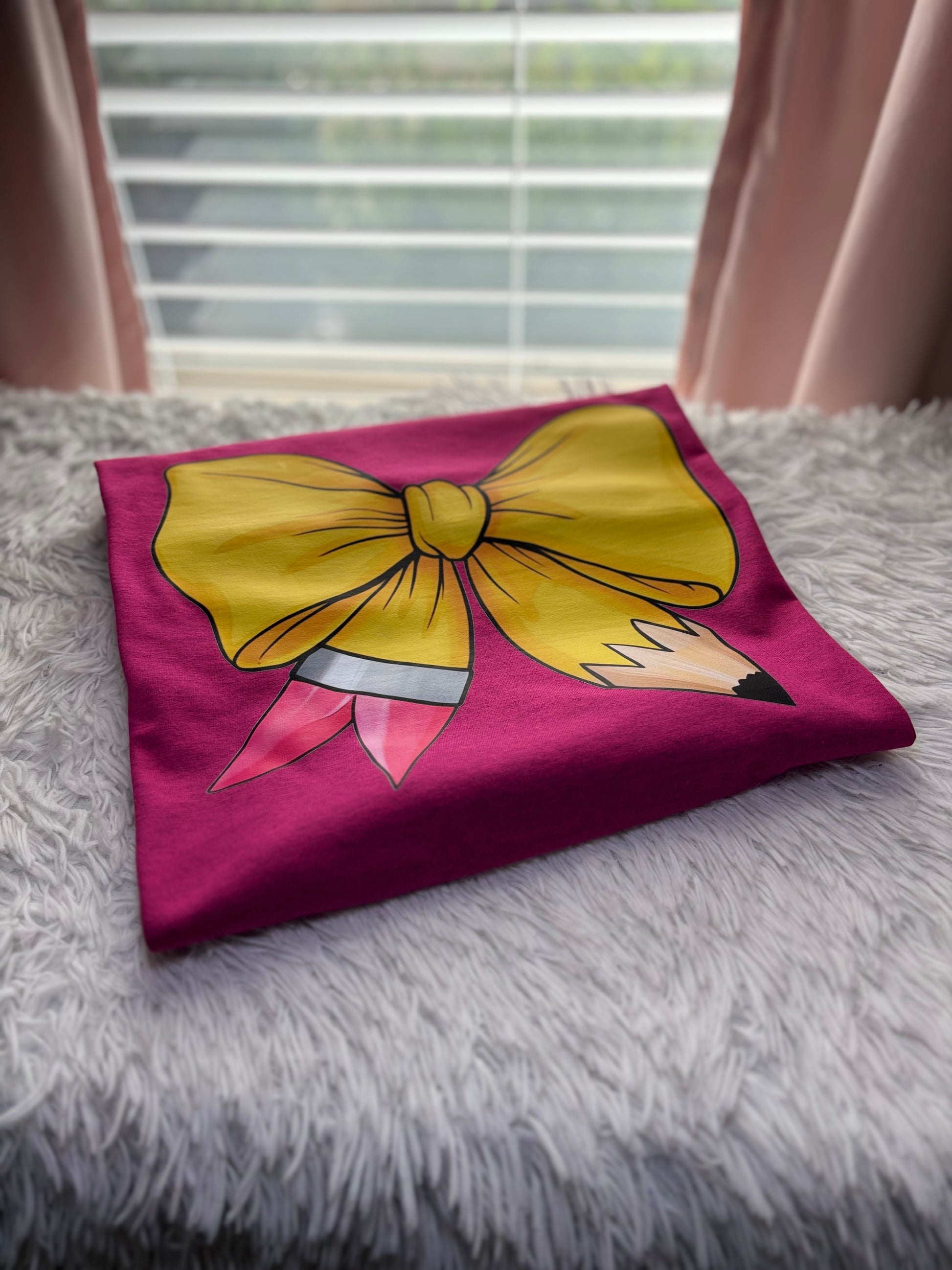 Pink heat press t-shirt with a large yellow pencil bow design