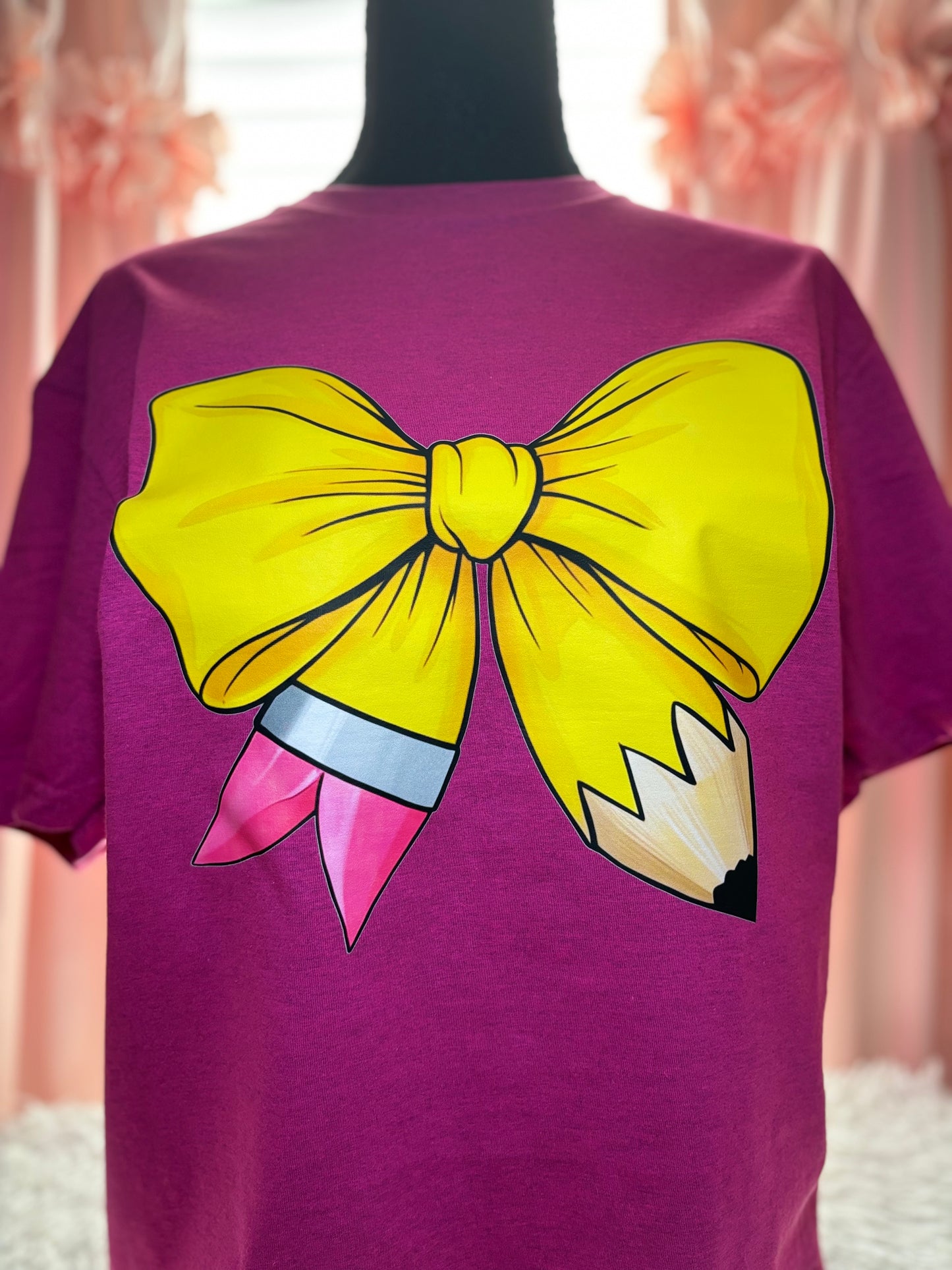 Pink heat press t-shirt with a large yellow pencil bow design