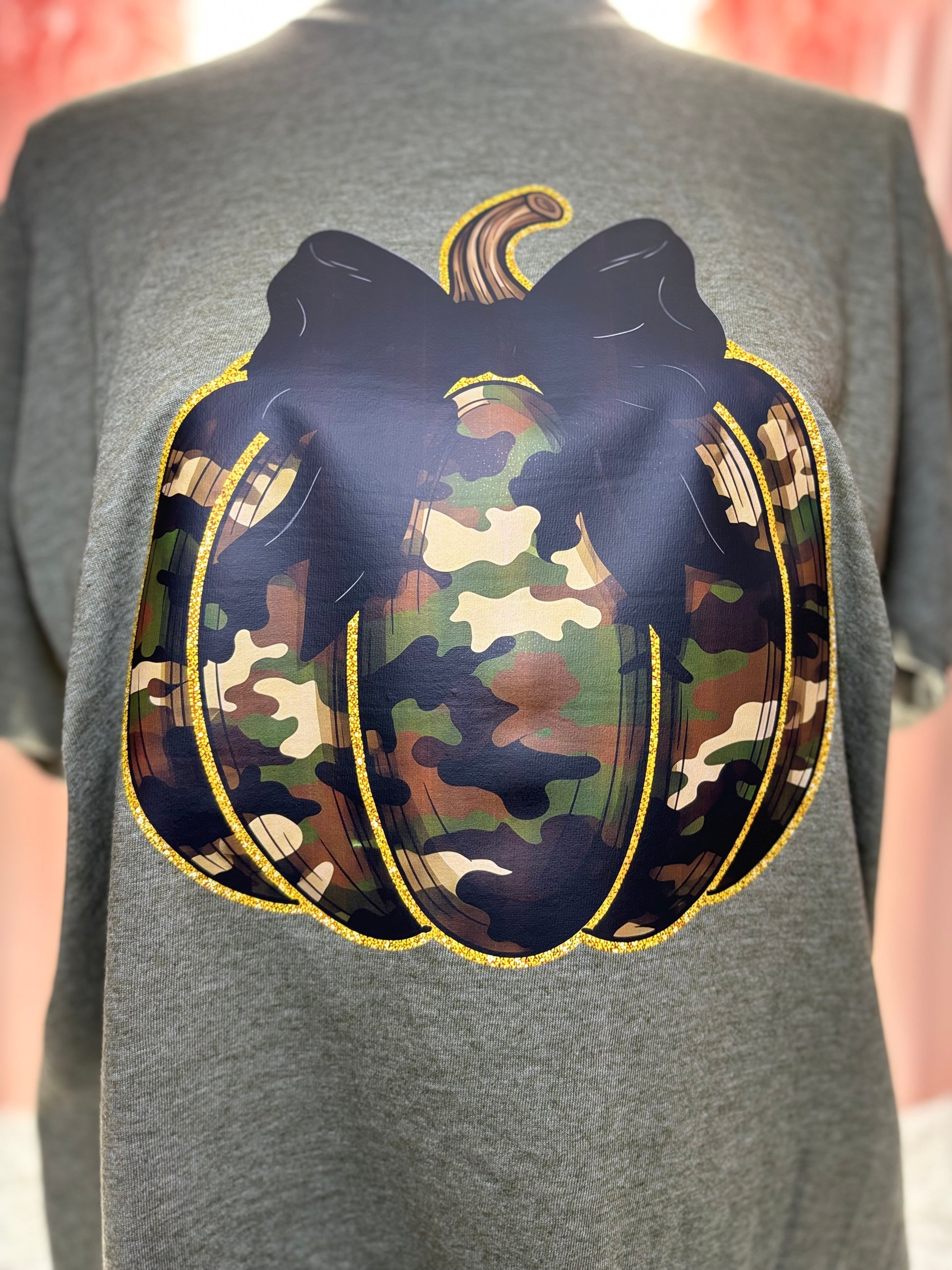 Military green t-shirt with a heat press camouflage pumpkin with bow and outlined in gold
