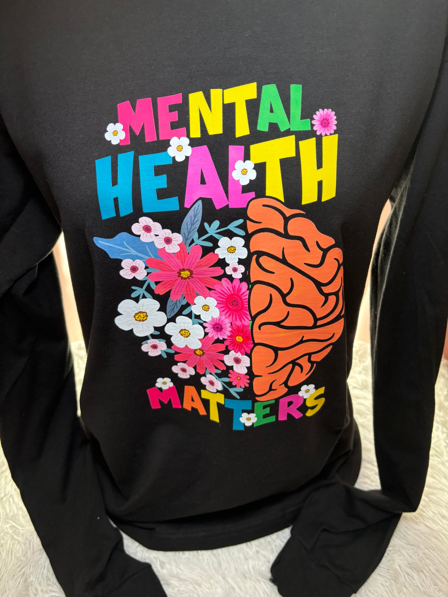Black long sleeve heat press t-shirt with a colorful brain and flowers design and 'Mental Health Matters' text.