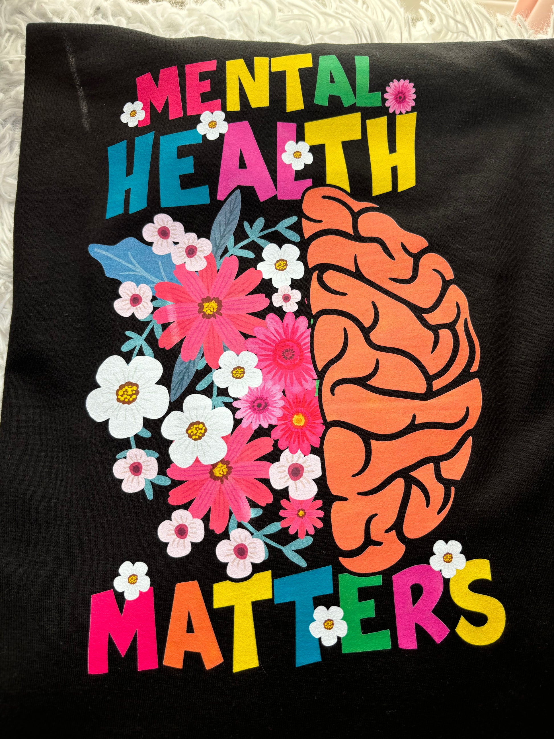 Black long sleeve heat press t-shirt with a colorful brain and flowers design and 'Mental Health Matters' text.