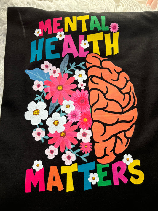 Black long sleeve heat press t-shirt with a colorful brain and flowers design and 'Mental Health Matters' text.