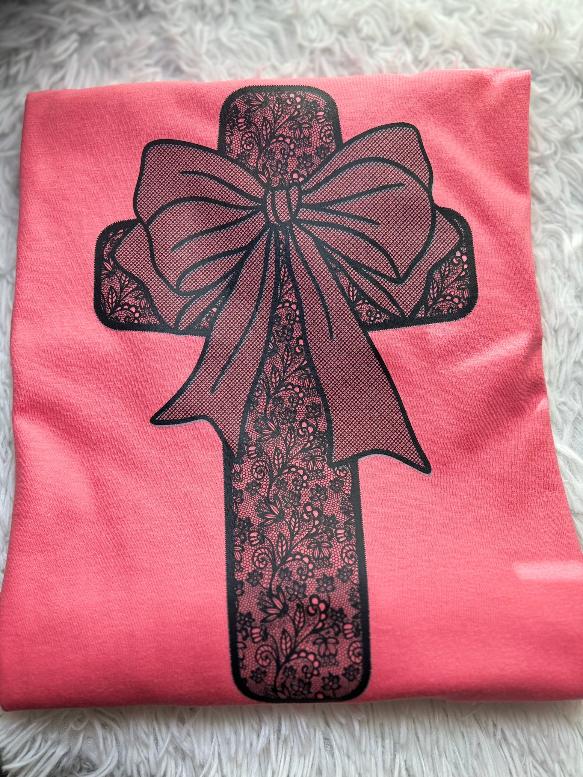 Coral heat press t-shirt with a black lace cross and bow design