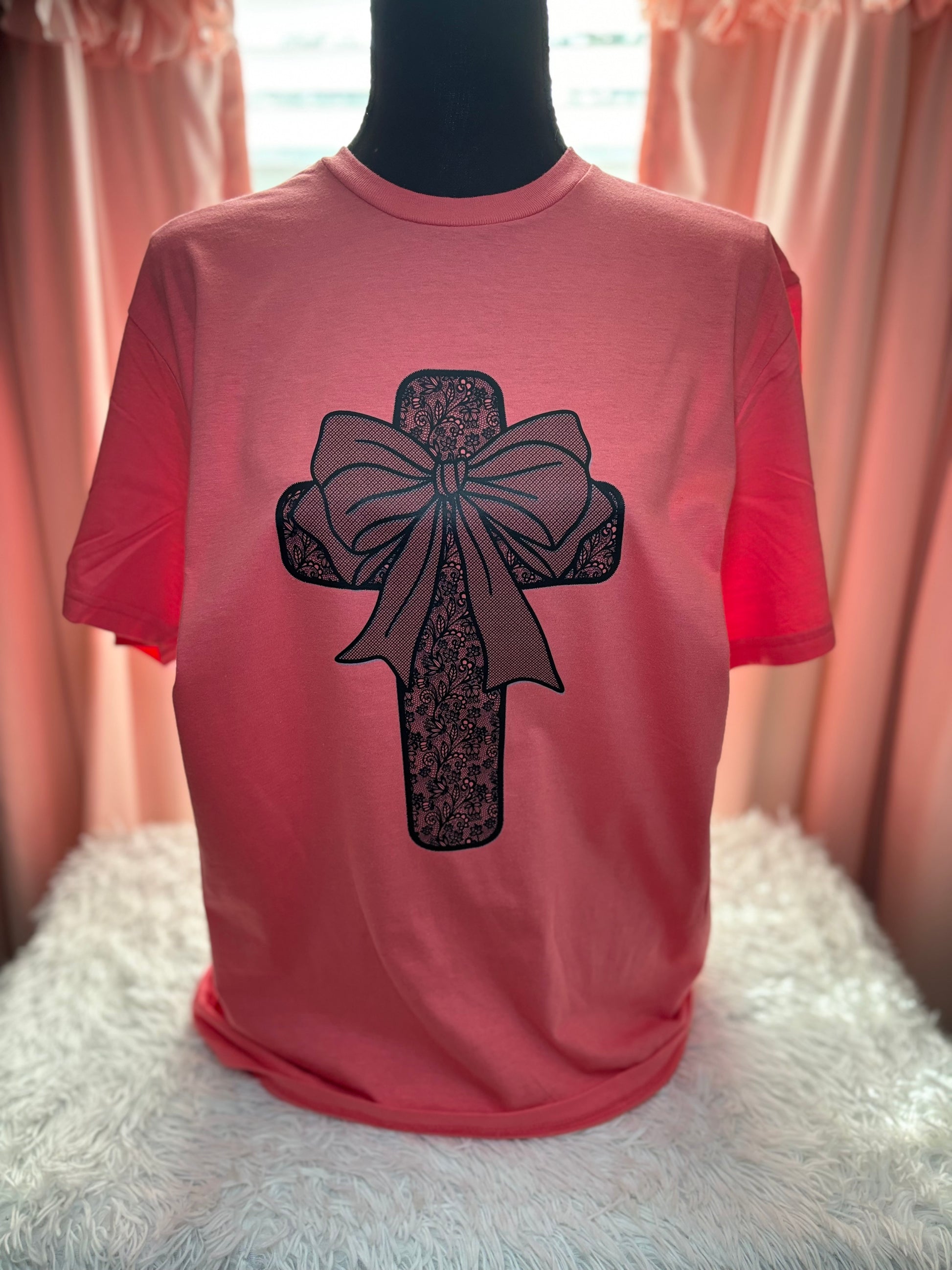 Coral heat press t-shirt with a black lace cross and bow design