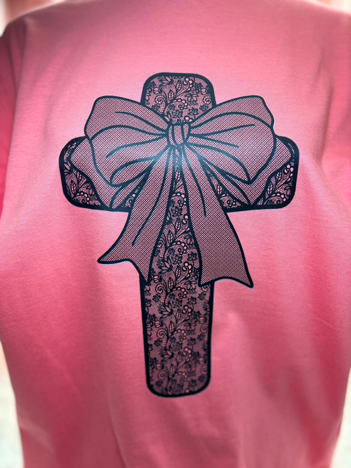 Coral heat press t-shirt with a black lace cross and bow design