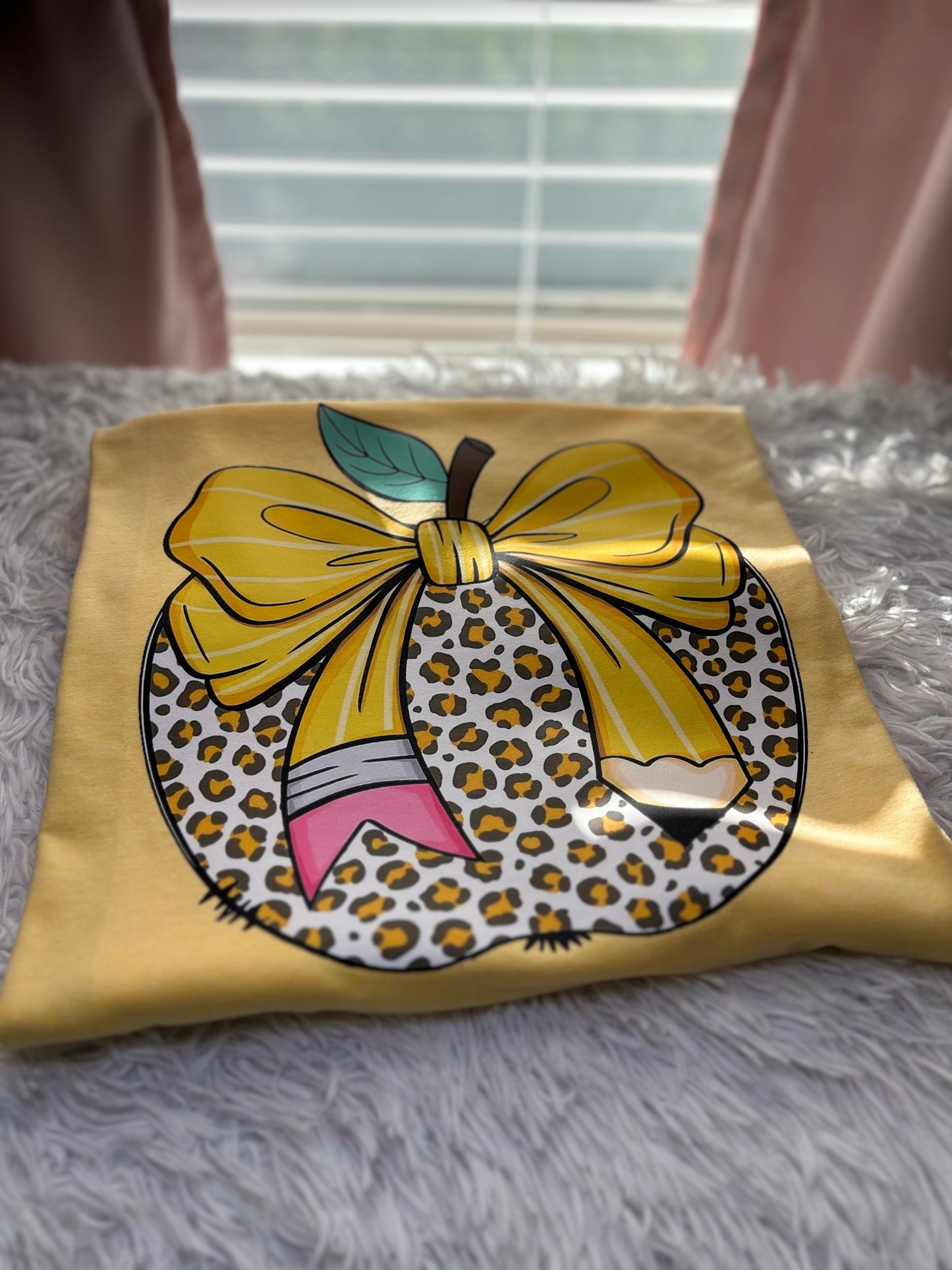 Yellow heat press t-shirt with a large pencil bow design on a leopard apple