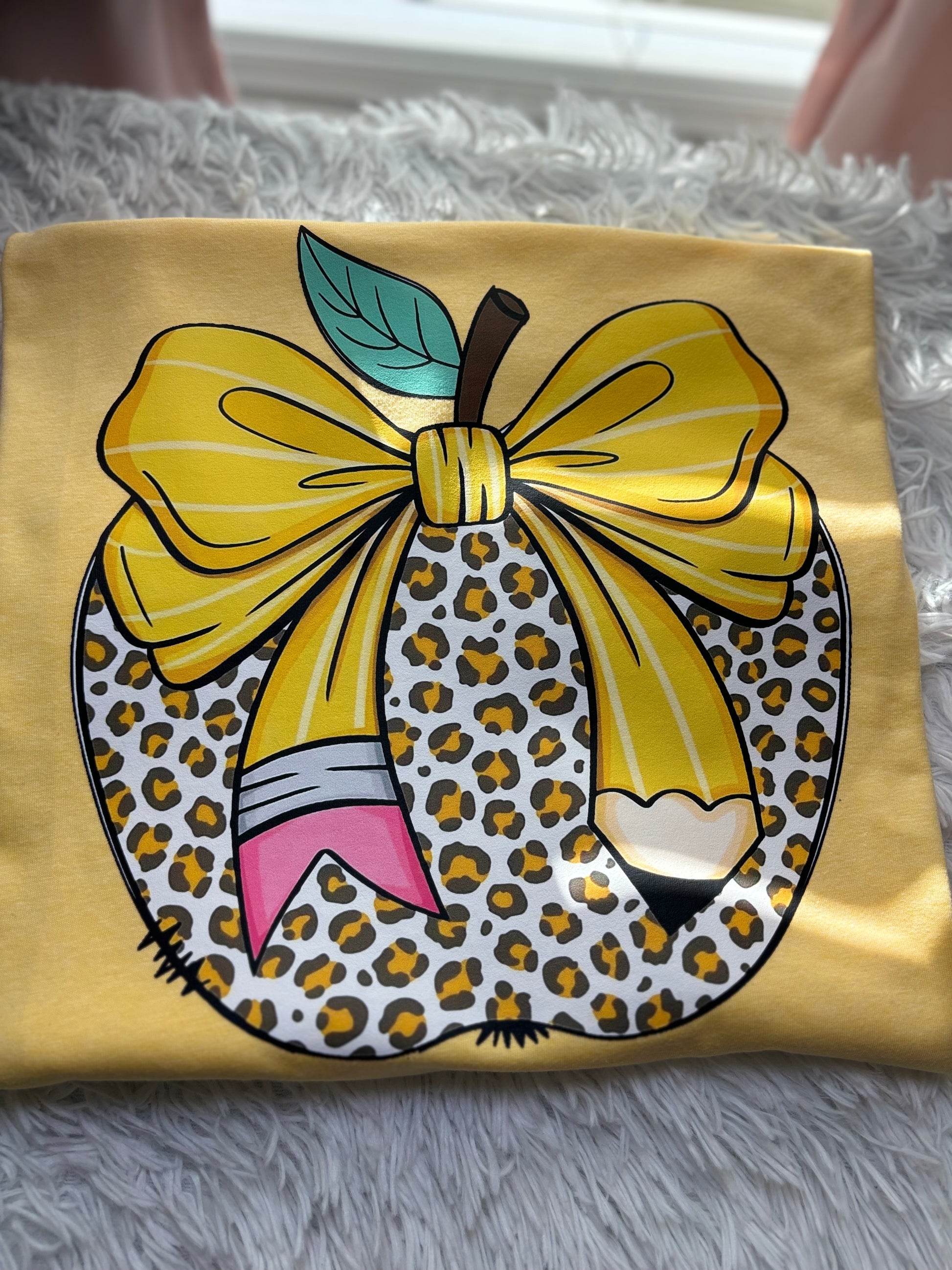 Yellow heat press t-shirt with a large pencil bow design on a leopard apple
