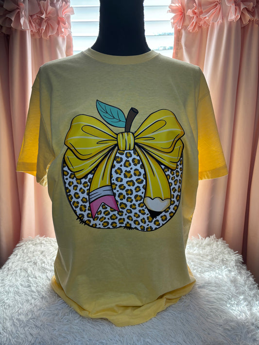 Yellow heat press t-shirt with a large pencil bow design on a leopard apple