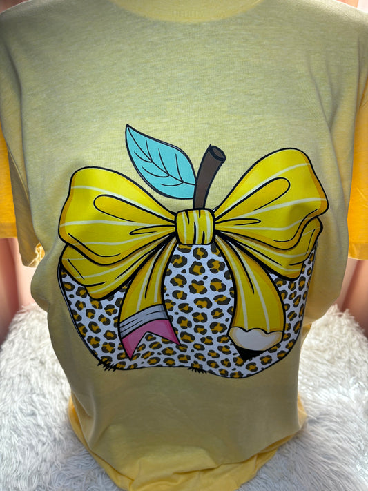 Yellow heat press t-shirt with a large pencil bow design on a leopard apple
