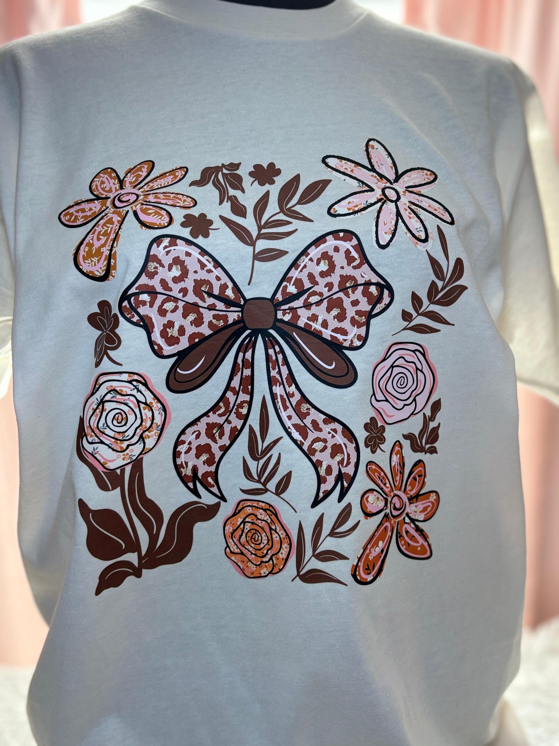 Beige t-shirt with a decorative heat press bow and floral patterns