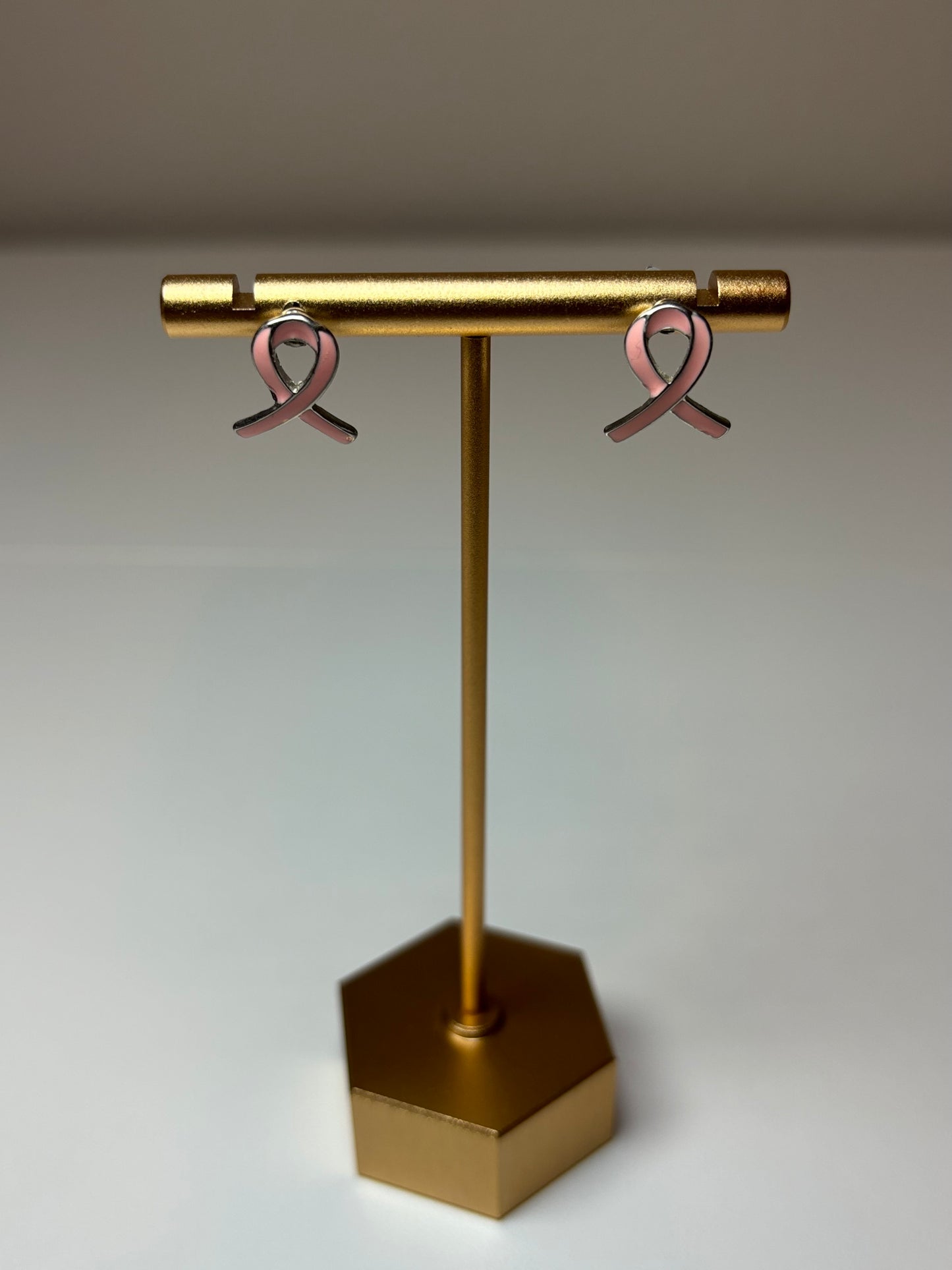 Pink ribbon earrings on a silver background