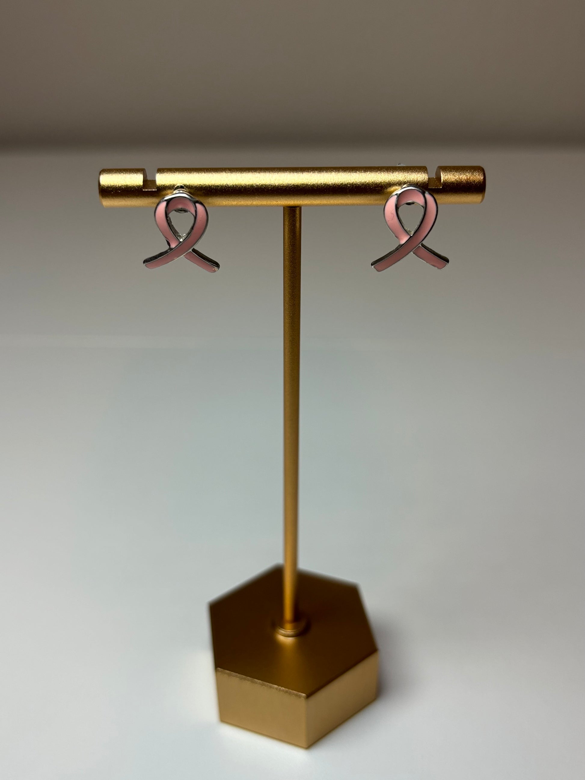 Pink ribbon earrings on a silver background