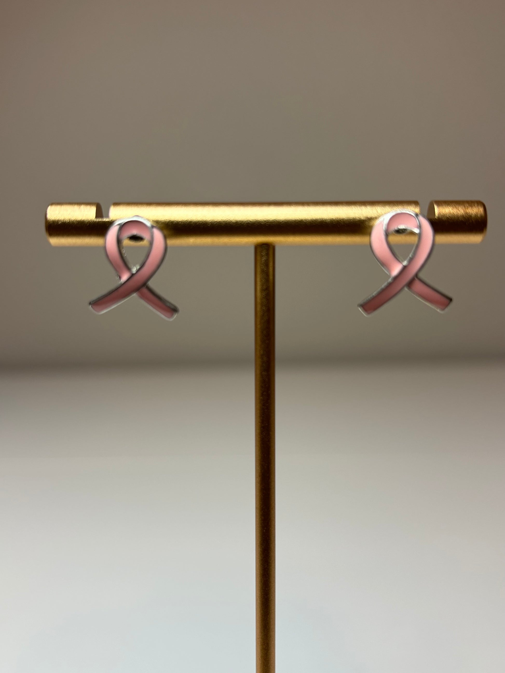 Pink ribbon earrings on a silver background