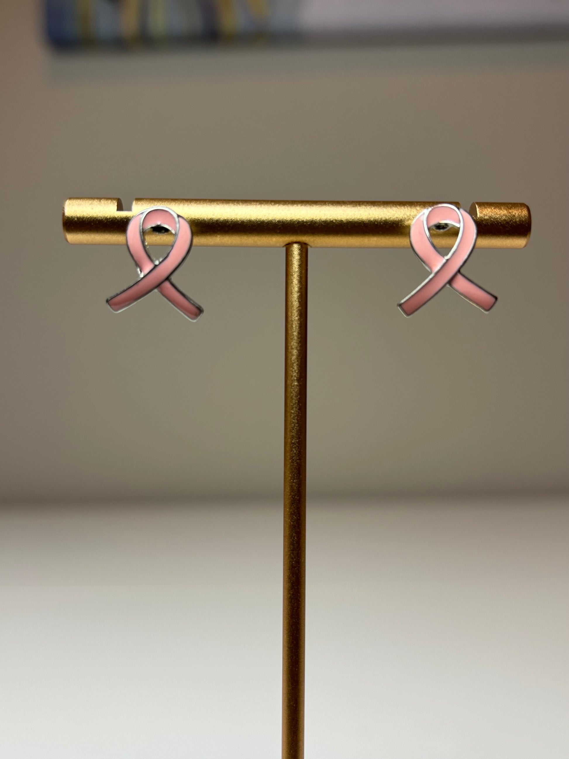 Pink ribbon earrings on a silver background