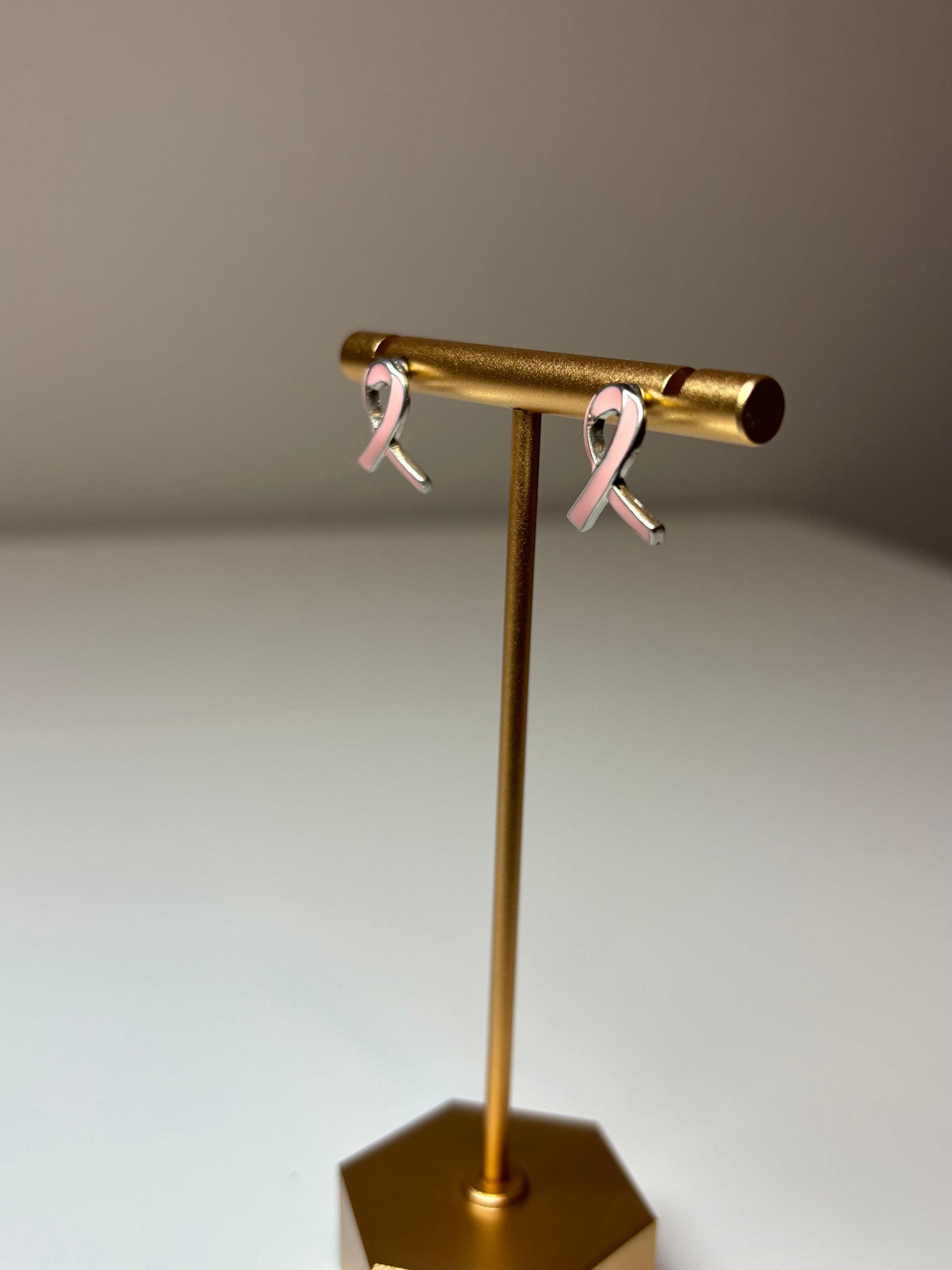 Pink ribbon earrings on a silver background