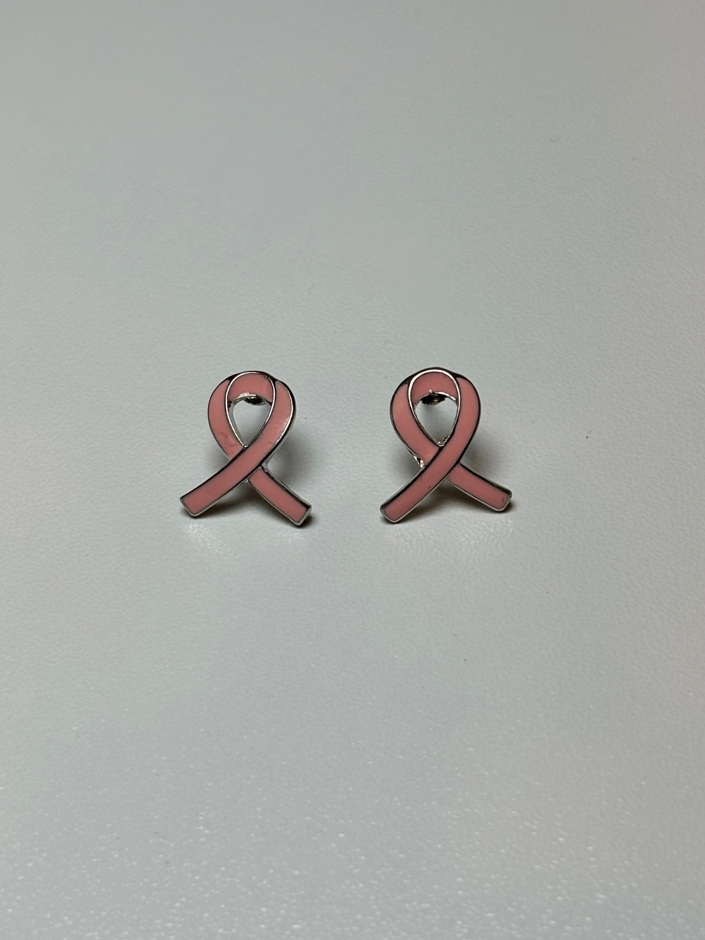 Pink ribbon earrings on a silver background