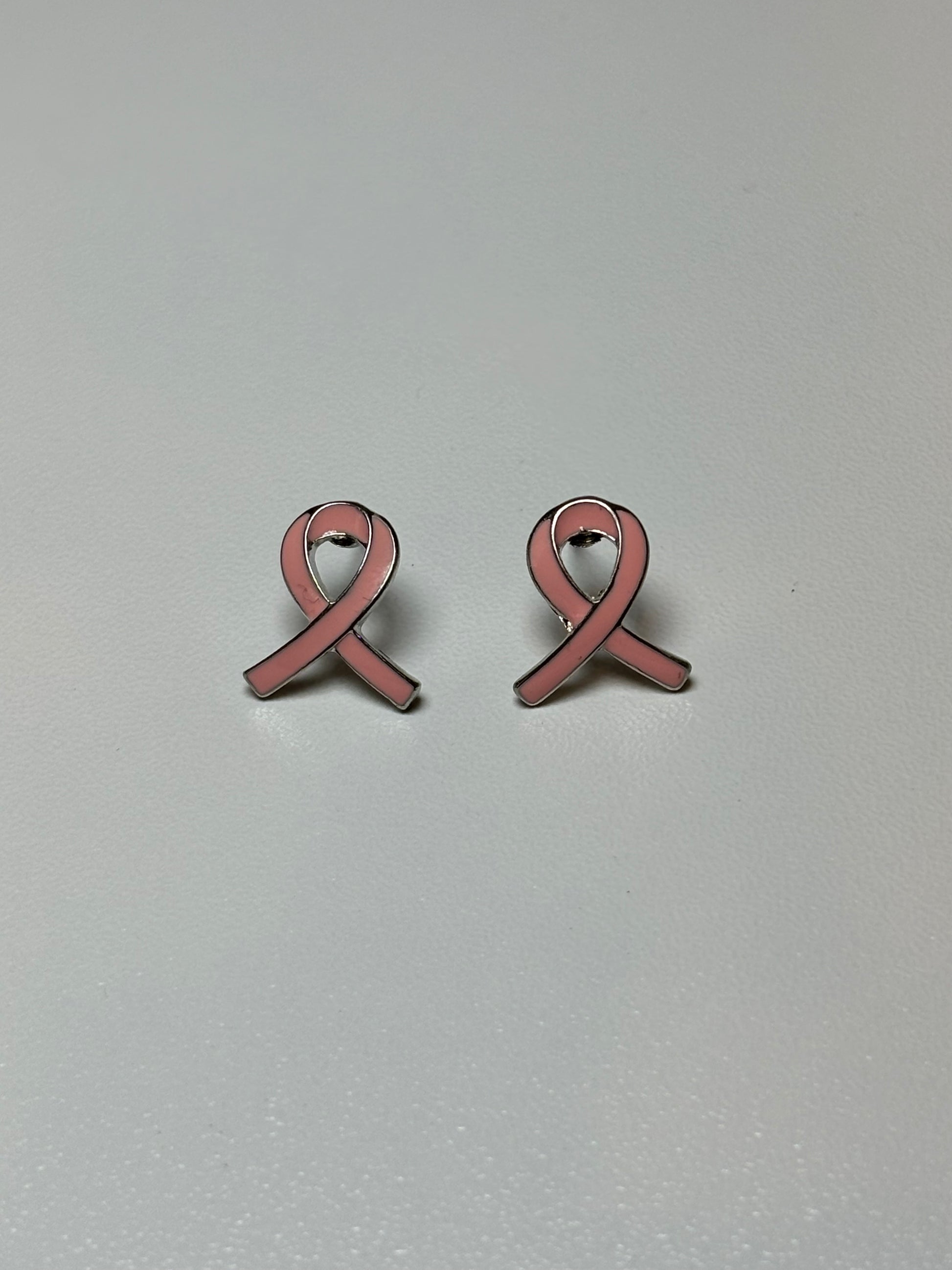 Pink ribbon earrings on a silver background