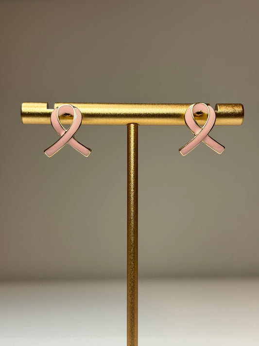 Pink ribbon earrings on a gold background