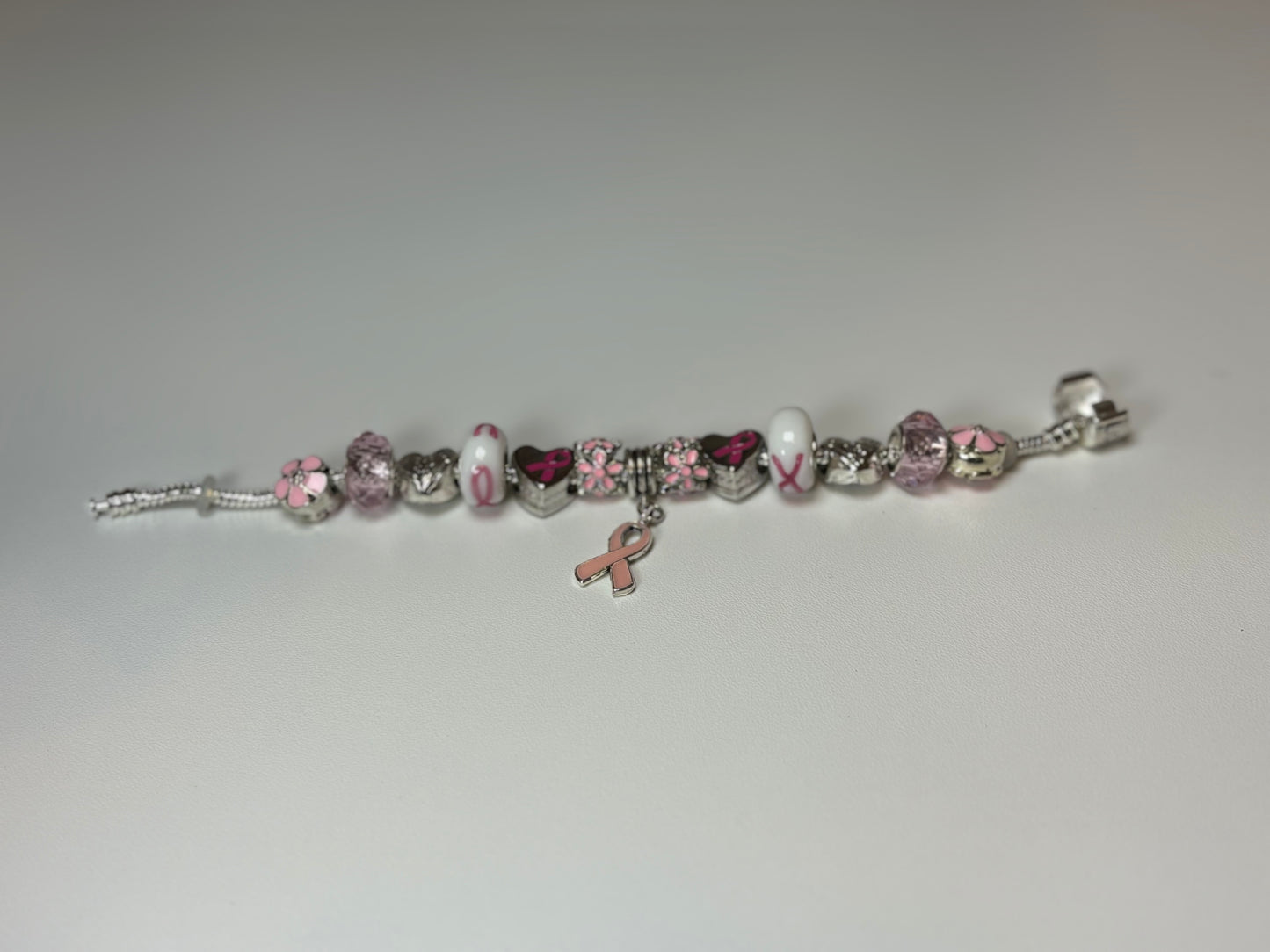Silver bracelet with pink ribbon and flower charms