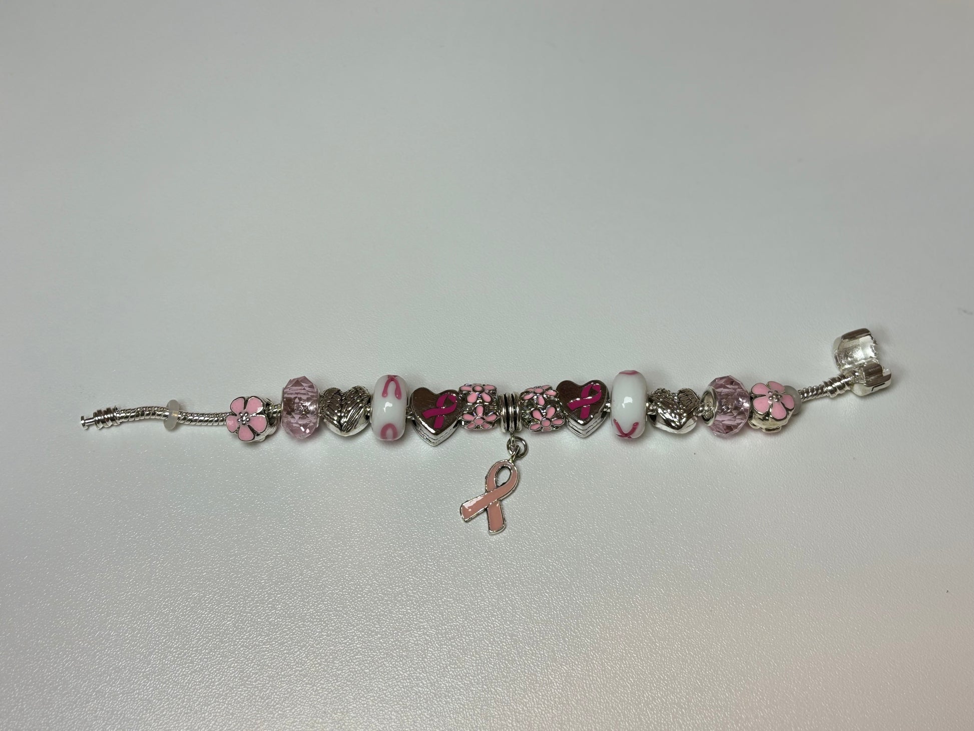 Silver bracelet with pink ribbon and flower charms