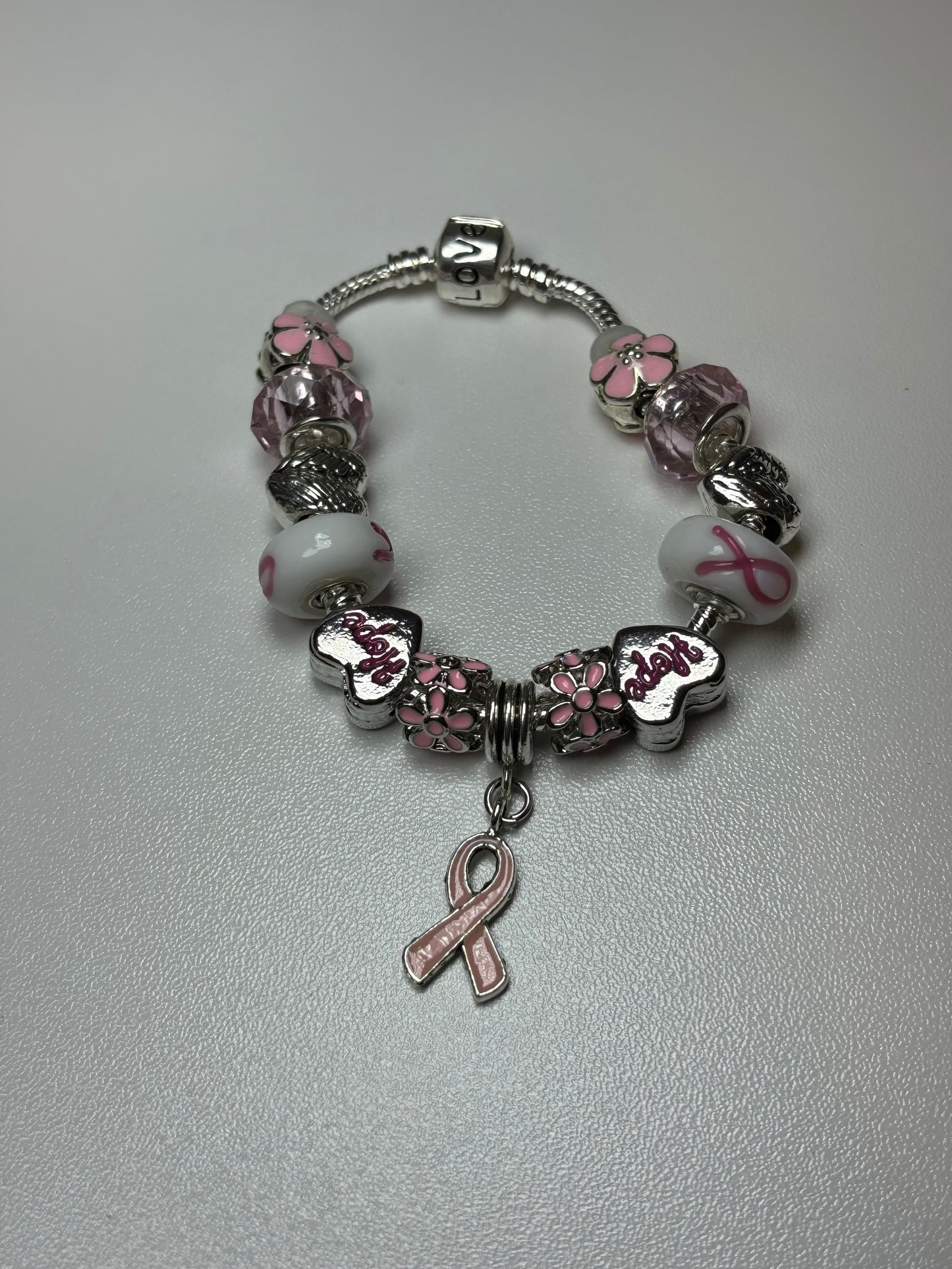 Silver bracelet with pink ribbon and flower charms
