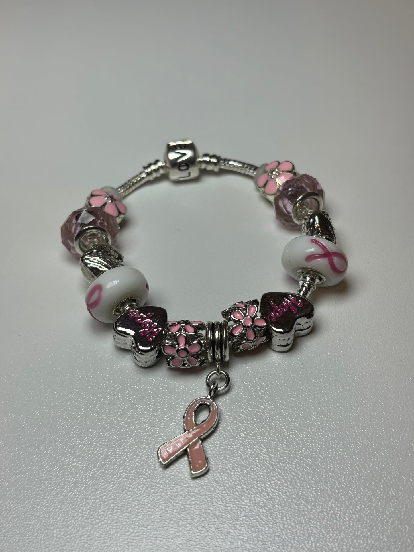 Silver bracelet with pink ribbon and flower charms