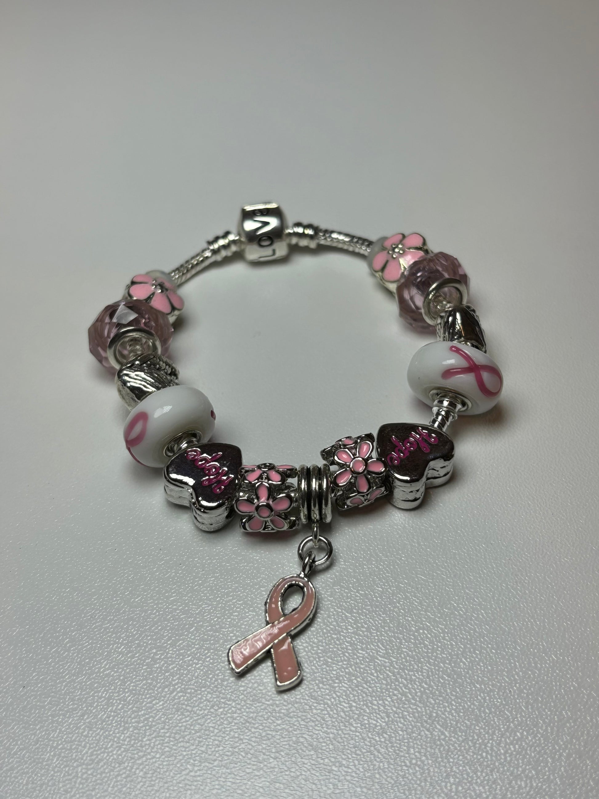 Silver bracelet with pink ribbon and flower charms