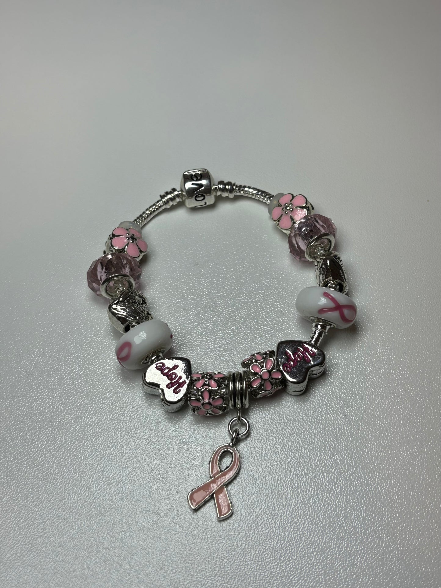 Silver bracelet with pink ribbon and flower charms