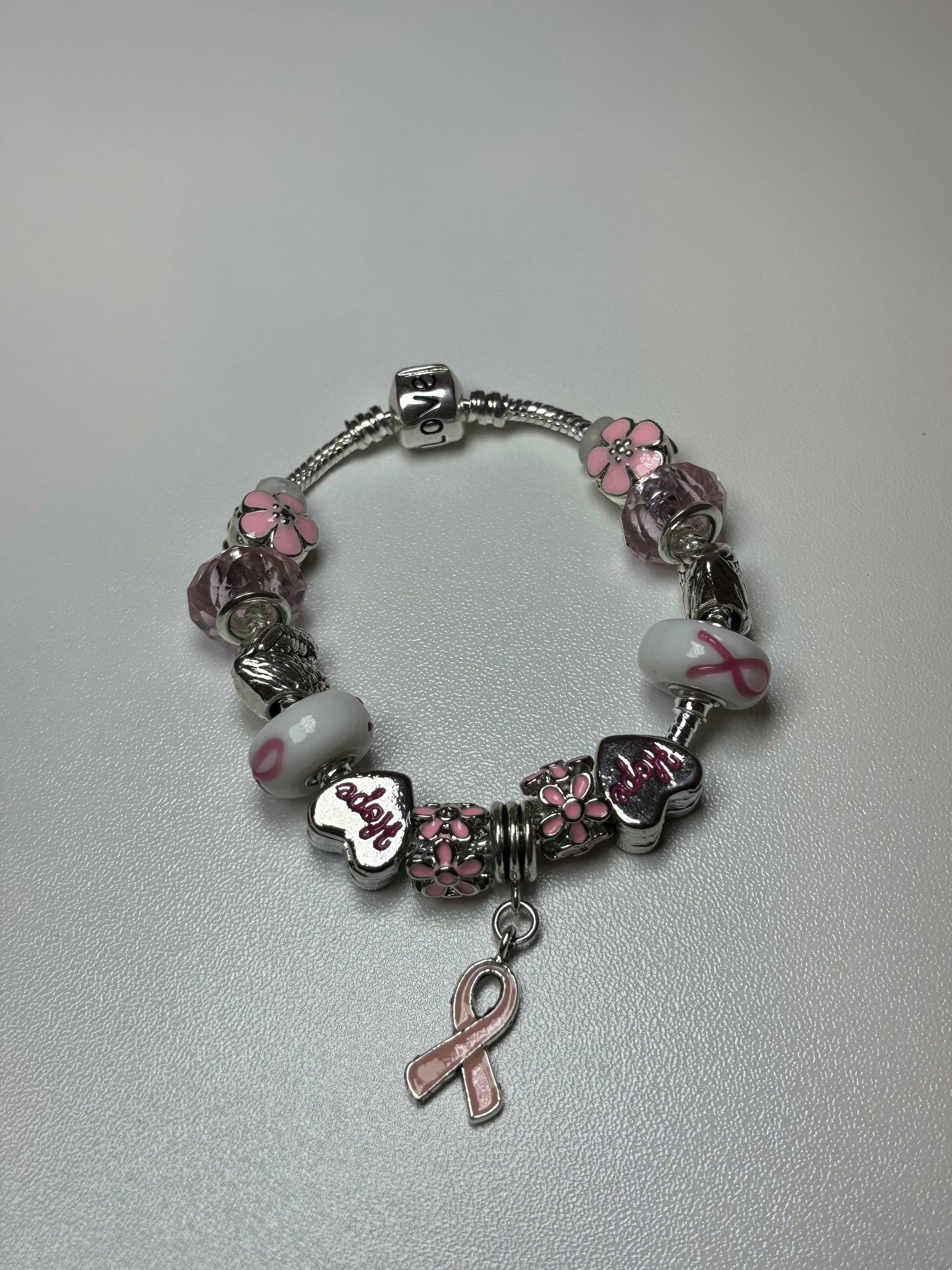 Silver bracelet with pink ribbon and flower charms