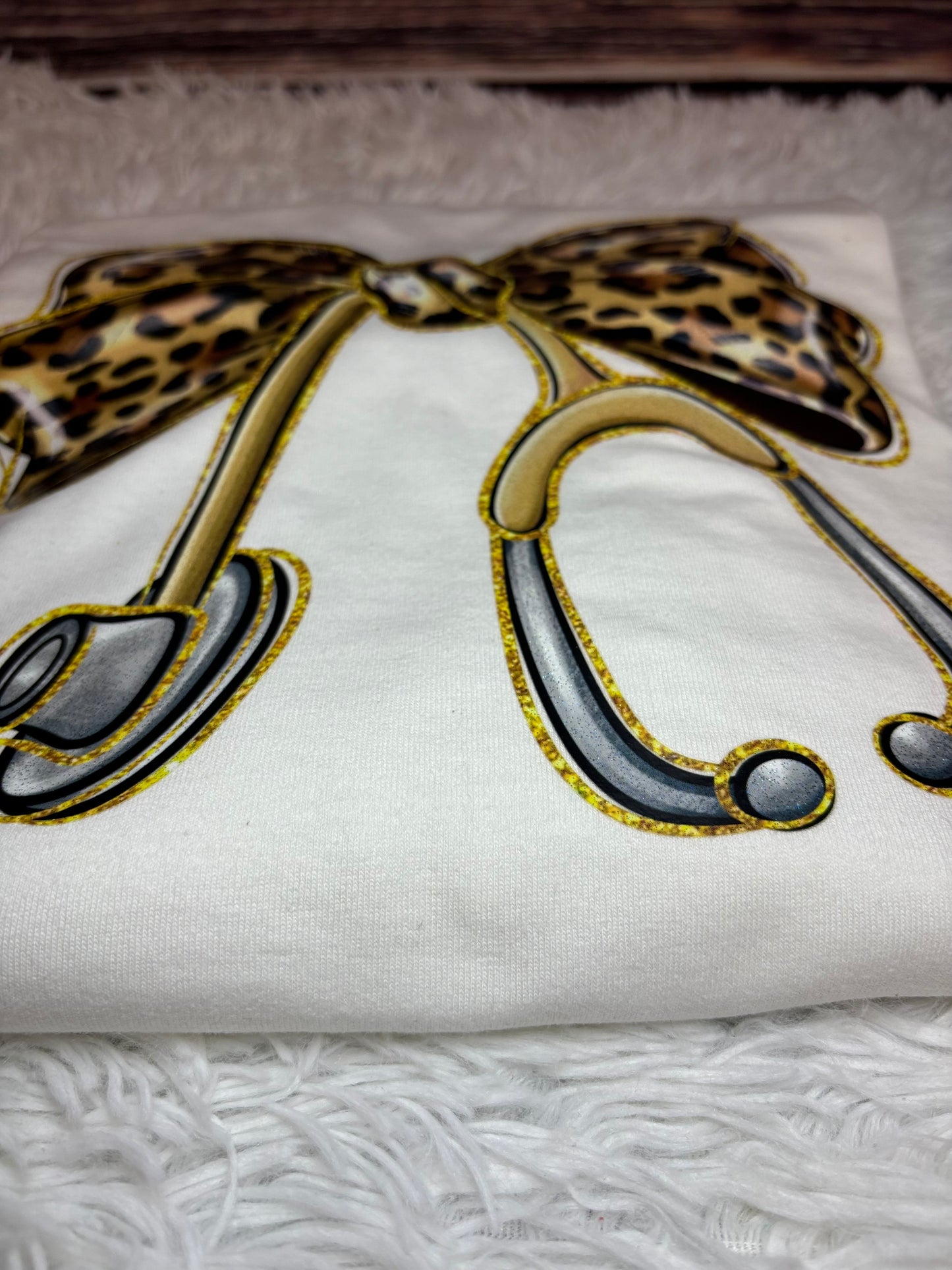 White long sleeve heat pressed t-shirt with a large leopard print bow nurse stethoscope design