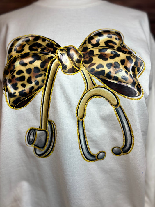 White long sleeve heat pressed t-shirt with a large leopard print bow nurse stethoscope design