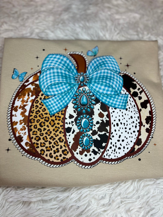 Decorative heat press t-shirt with a western pumpkin that has blue checkered bow, leopard print, and polka dot patterns.