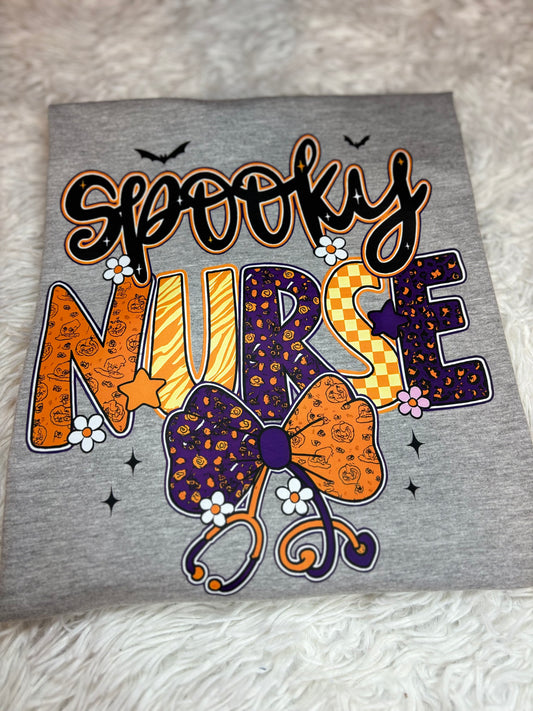 Gray heat press shirt with 'Spooky Nurse' design featuring Halloween elements- bats, stethoscope, flowers, stars